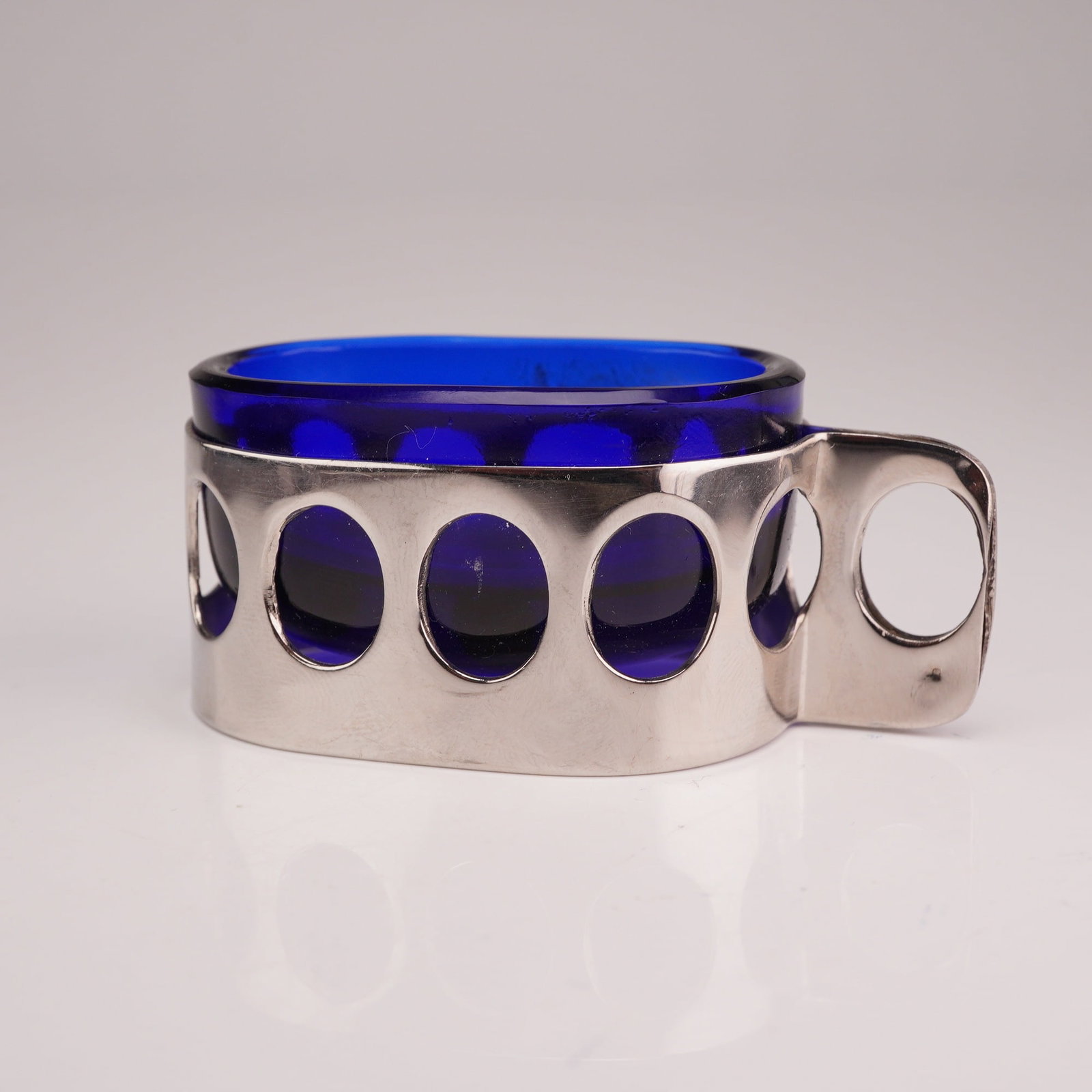 Lantel Inox Cobalt Blue Glass and Stainless Steel Open Salt Cellar: This mid-century modern open salt cellar consists of a deep cobalt blue glass liner set within a polished stainless steel frame. The frame features a series of vertical oval pierced cutouts around the