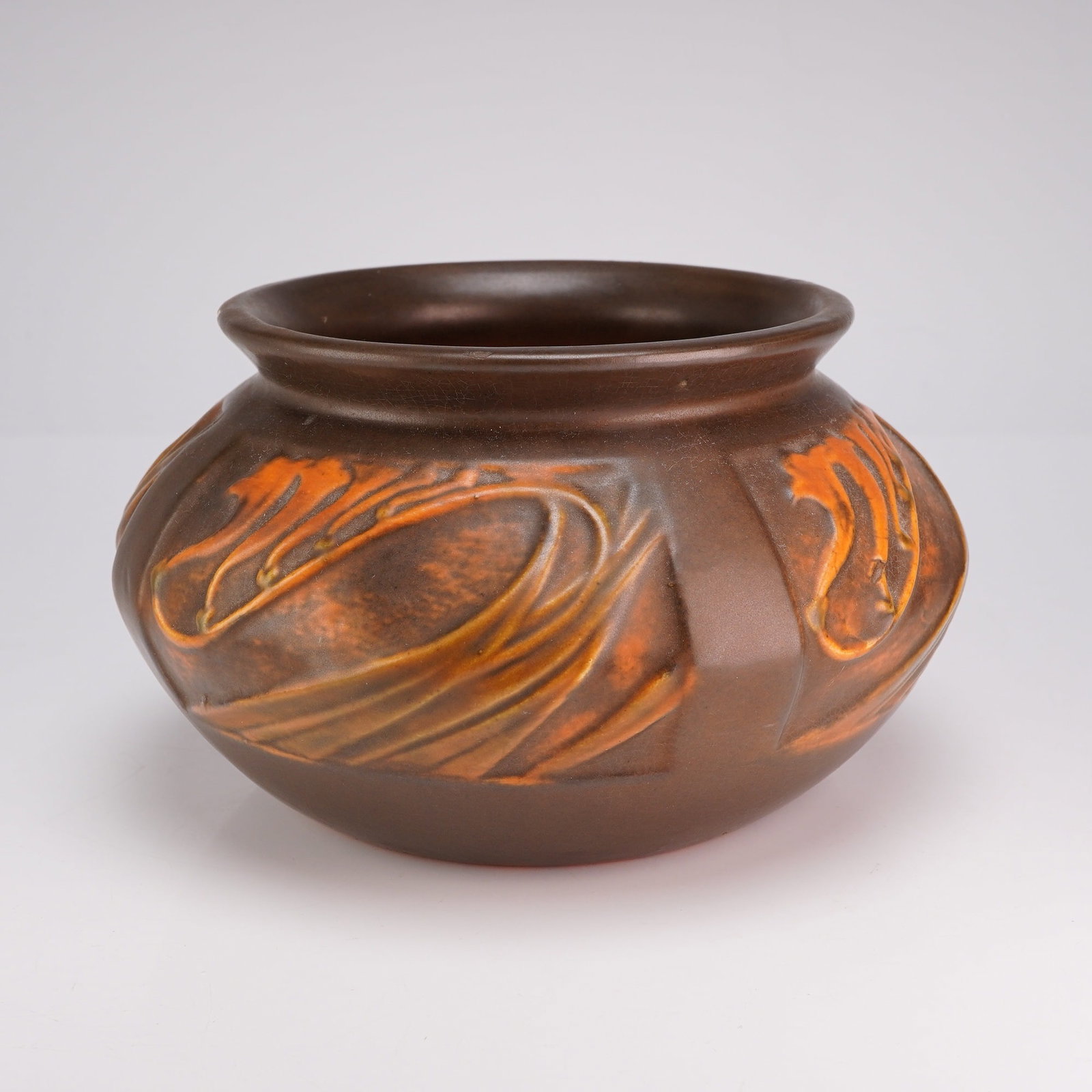 Roseville Pottery Panel Pattern Jardiniere, Freesia Brown: This Roseville Rosecraft Panel art pottery jardiniere, introduced circa 1926, features a squat, bulbous form with a wide, flared rim. The exterior body is divided into vertical panels, each