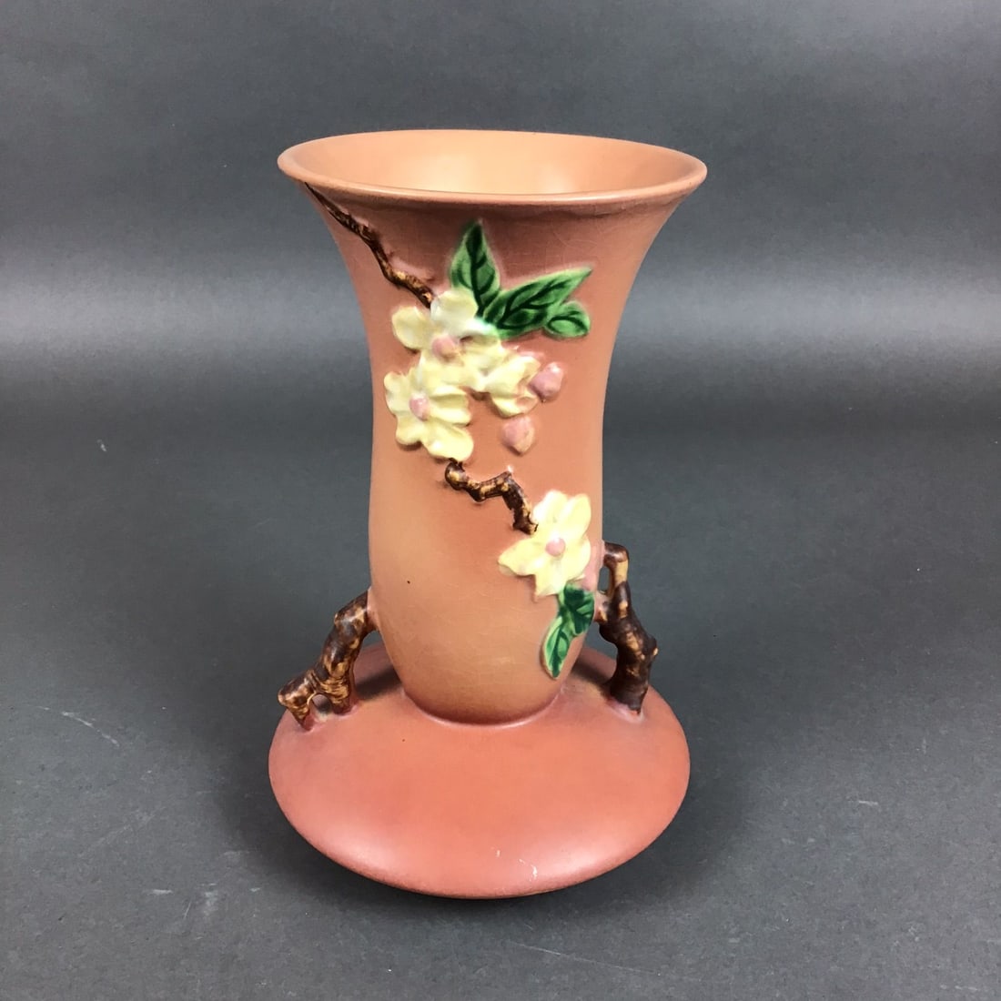 Roseville Pottery Dual Handled Vase, Apple Blossom: This Roseville art pottery vase is decorated in the Apple Blossom pattern, shape number 368-10. The vessel is made of glazed earthenware and features a trumpet-shaped form with a flared rim. The body