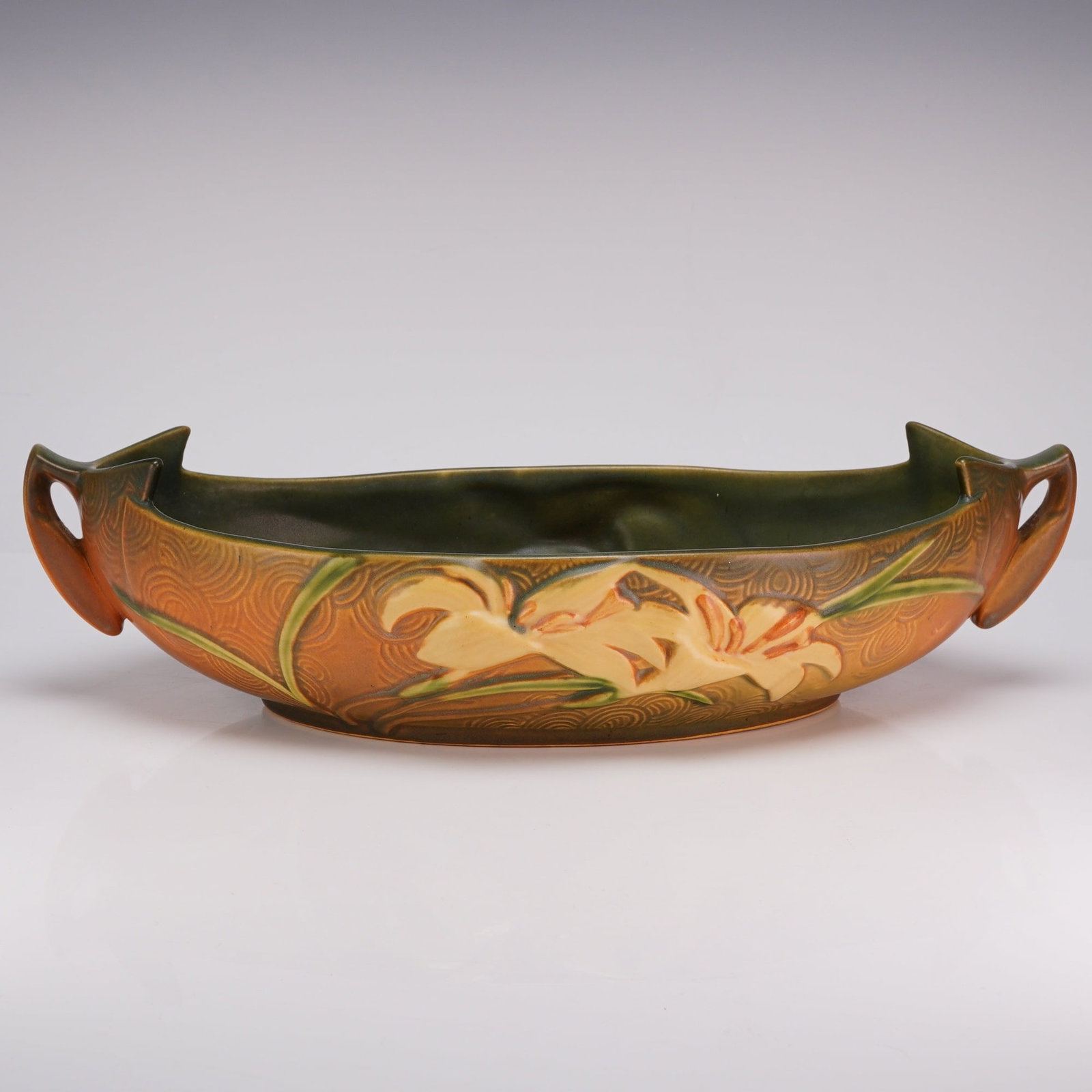 Roseville Pottery Console Bowl, Zephyr Lily Brown: This Roseville Pottery console bowl is decorated in the Zephyr Lily pattern, which was introduced by the company in 1946. The earthenware vessel features a low, elongated boat-shaped form with two int