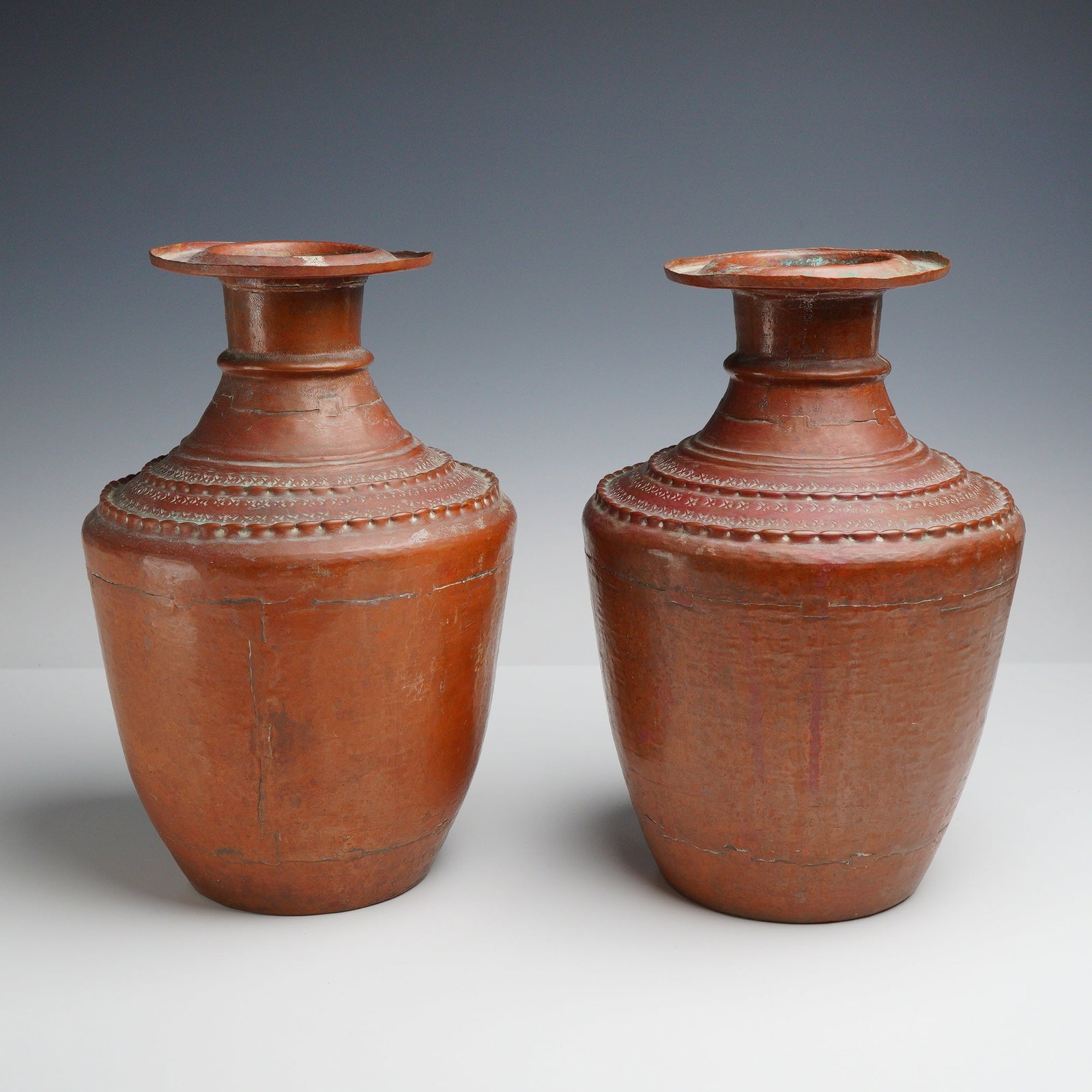 Pair of South Asian Hand Hammered Brass Urns: A pair of large brass urns or water vessels, traditionally known as gagri or lota style, originating from Northern India or Nepal. These vessels are constructed from multiple sheets of hand hammered m