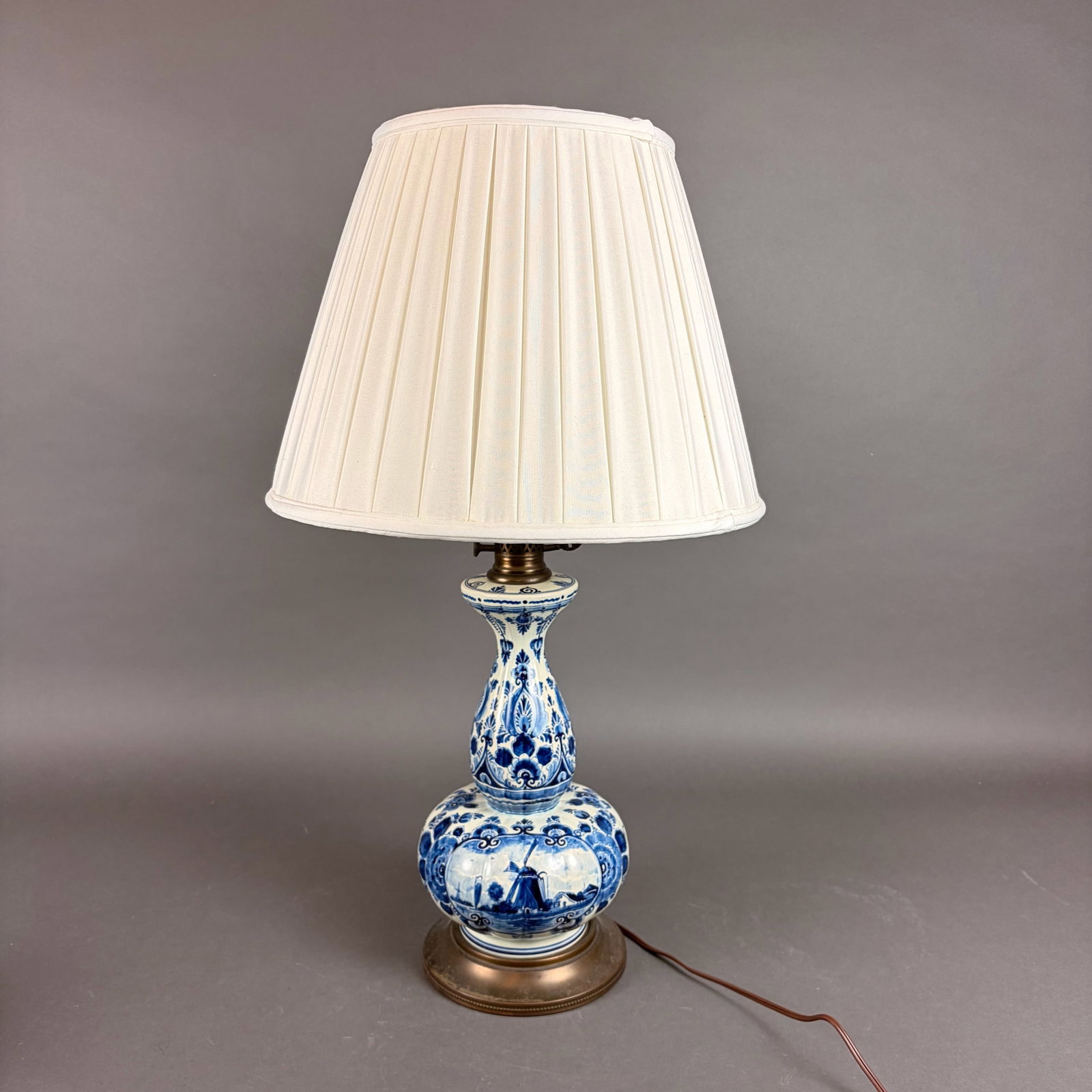 Delft Style Blue and White Ceramic Double Gourd Table Lamp: A Delft style ceramic table lamp featuring a double-gourd form with hand-painted blue and white decoration. The lower bulbous section depicts a traditional Dutch windmill scene within a circular carto