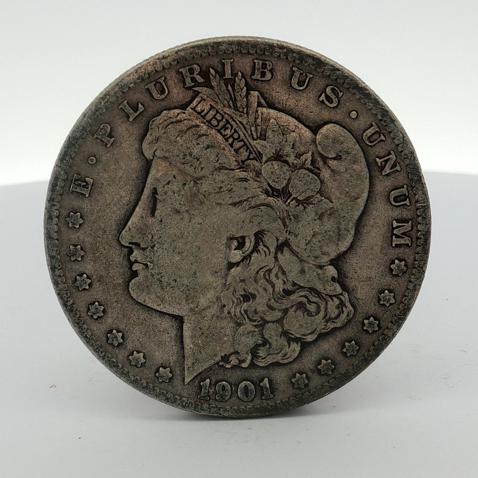 1901-O US Morgan Silver Dollar: This US 1901-O Morgan silver dollar was produced at the New Orleans Mint. The coin features the Morgan dollar design on the obverse with the date 1901 and the legend E PLURIBUS UNUM. The reverse displ