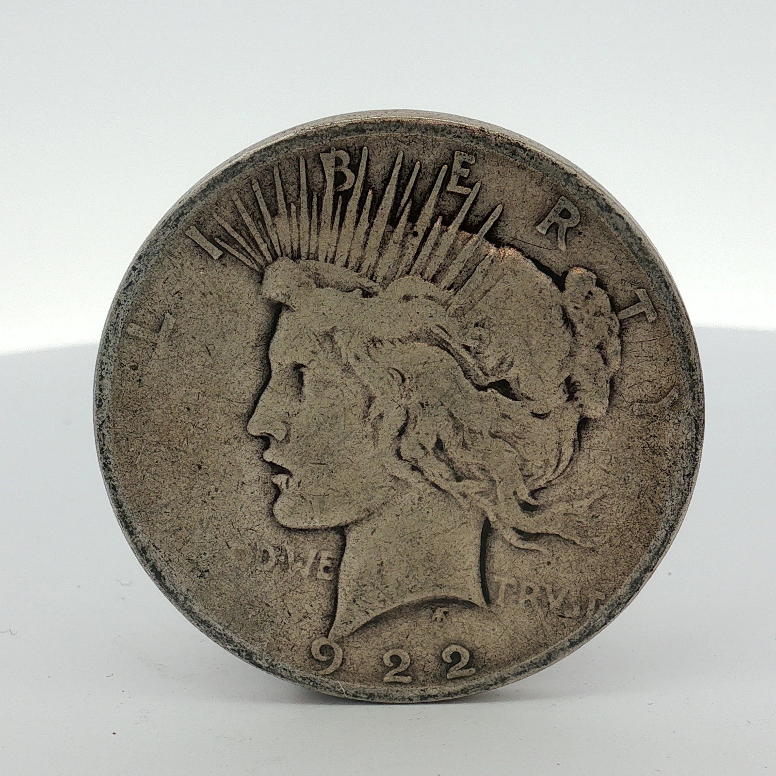 1922-D One Dollar Peace Silver Dollar, Circulated: This US Peace dollar is dated 1922-D and was struck at the Denver Mint. The coin is composed of 90 percent silver and 10 percent copper. It features the standard Peace dollar design on both the obvers