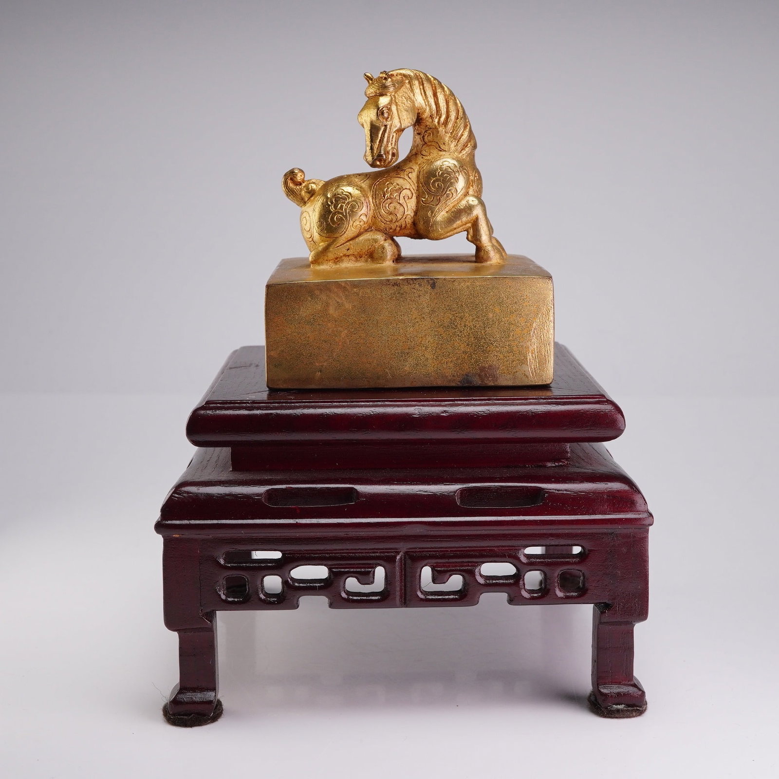 Qing Dynasty Gilded Bronze Large Horse Seal: A Chinese gilded ferrous bronze imperial seal, surmounted by a recumbent horse finial adorned with delicate incised scrollwork. The rectangular base bears a six-character inscription in seal script re