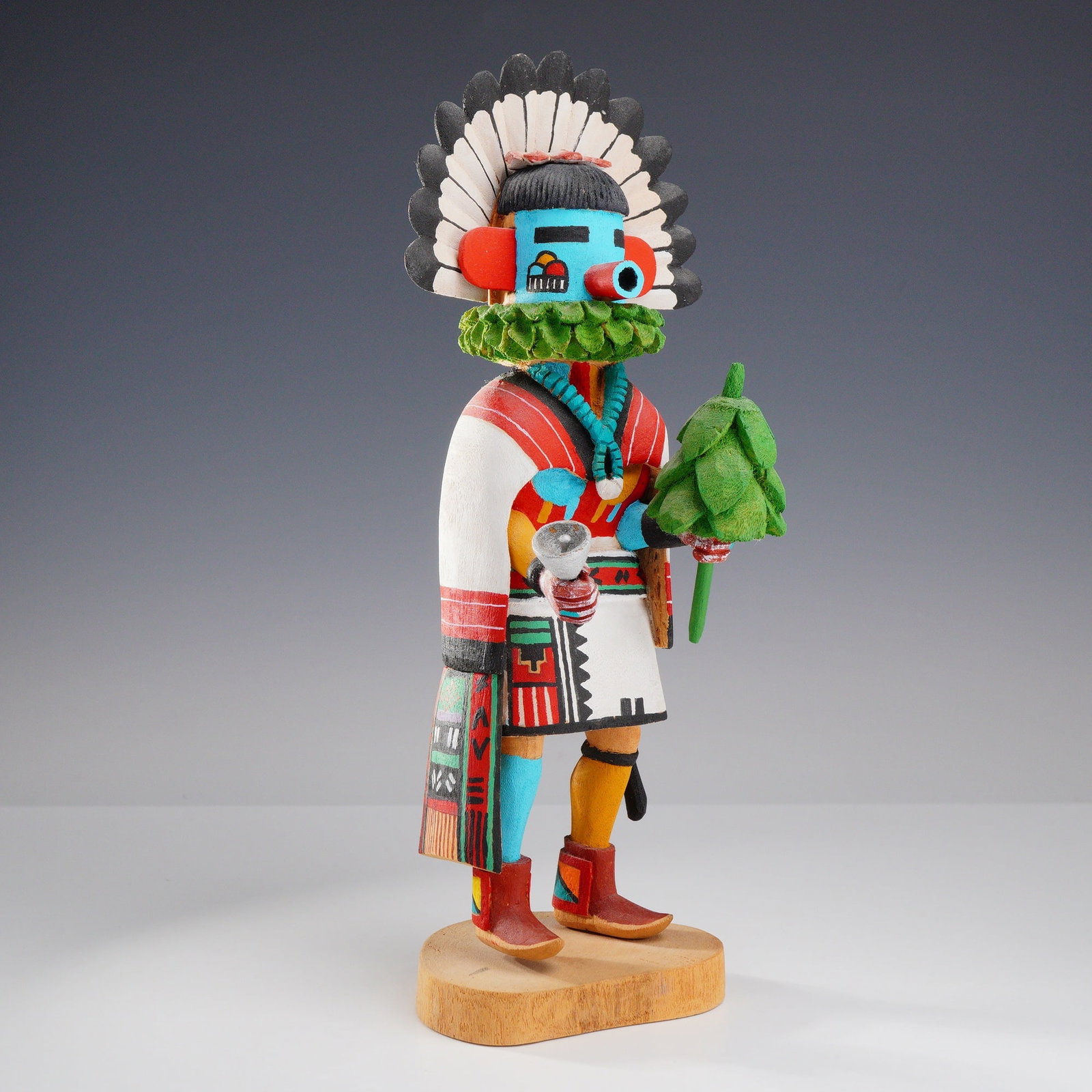 Hopi Hand Carved Wooden Morning Singer Kachina Doll by Andrew Cooley, Signed: A hand-carved and polychrome painted Hopi kachina doll representing the Talavai, or Morning Singer, crafted from cottonwood root. The figure features a turquoise-blue mask with a tubular red snout, re