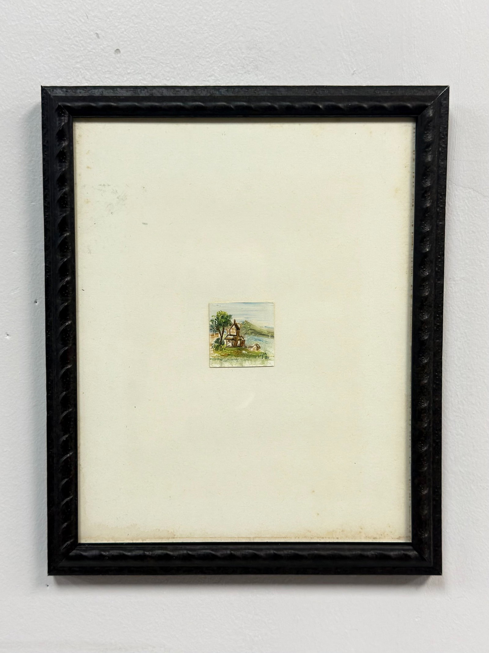 Framed Miniature Original Gouache Landscape Painting, Signed and Dated 1980: This framed miniature original painting on paper depicts a small gabled cottage situated on a grassy bank beside a body of water, with rolling hills in the background and a single tree to the left. Th