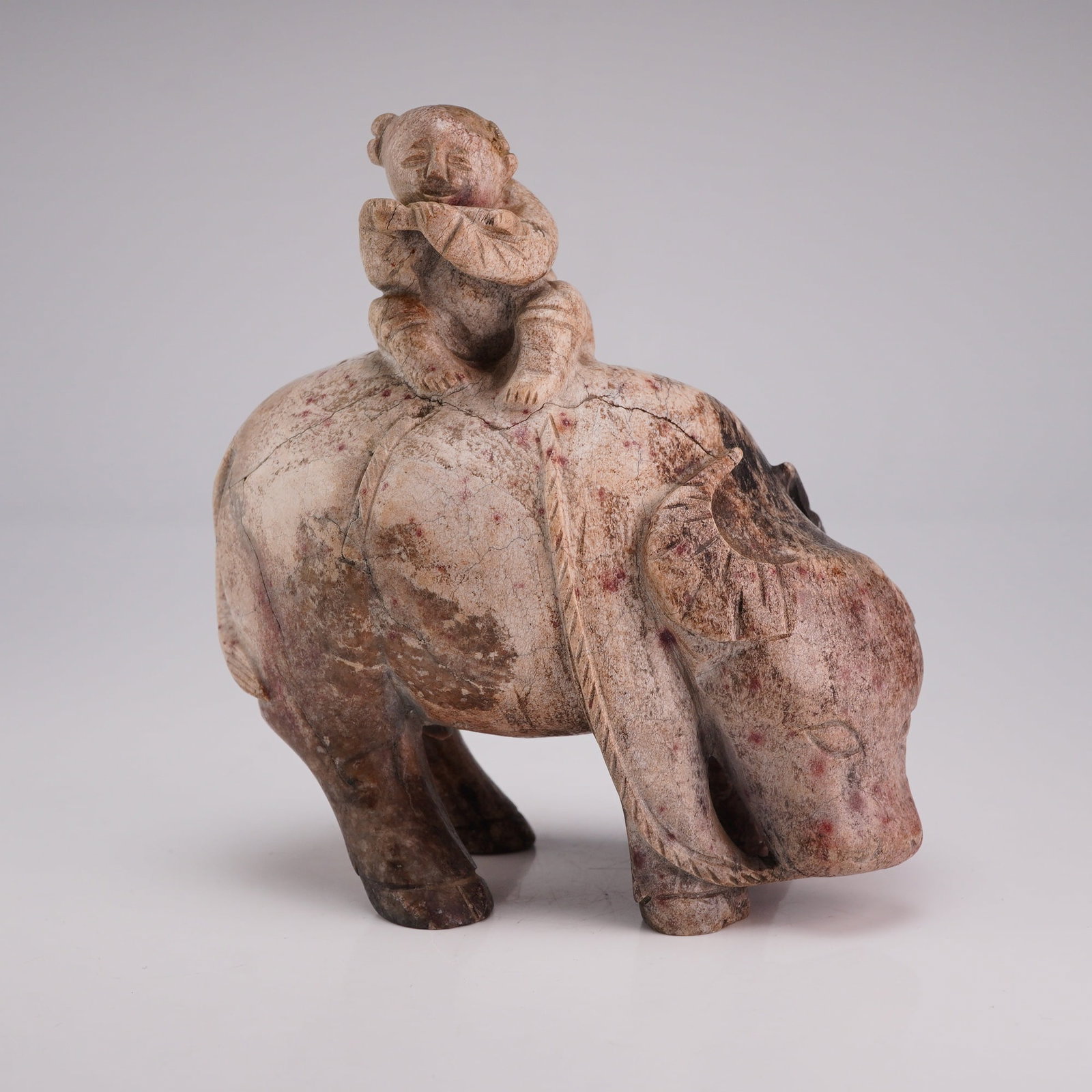 Nephrite Chicken Bone Jade Carving, Boy on Water Buffalo, Ming Dynasty: A carved nephrite chicken bone jade figurine depicting a boy sitting on the back of a water buffalo. Dimensions 4"L x 2.25"W x 3.75"H Weight 1.40 lbs