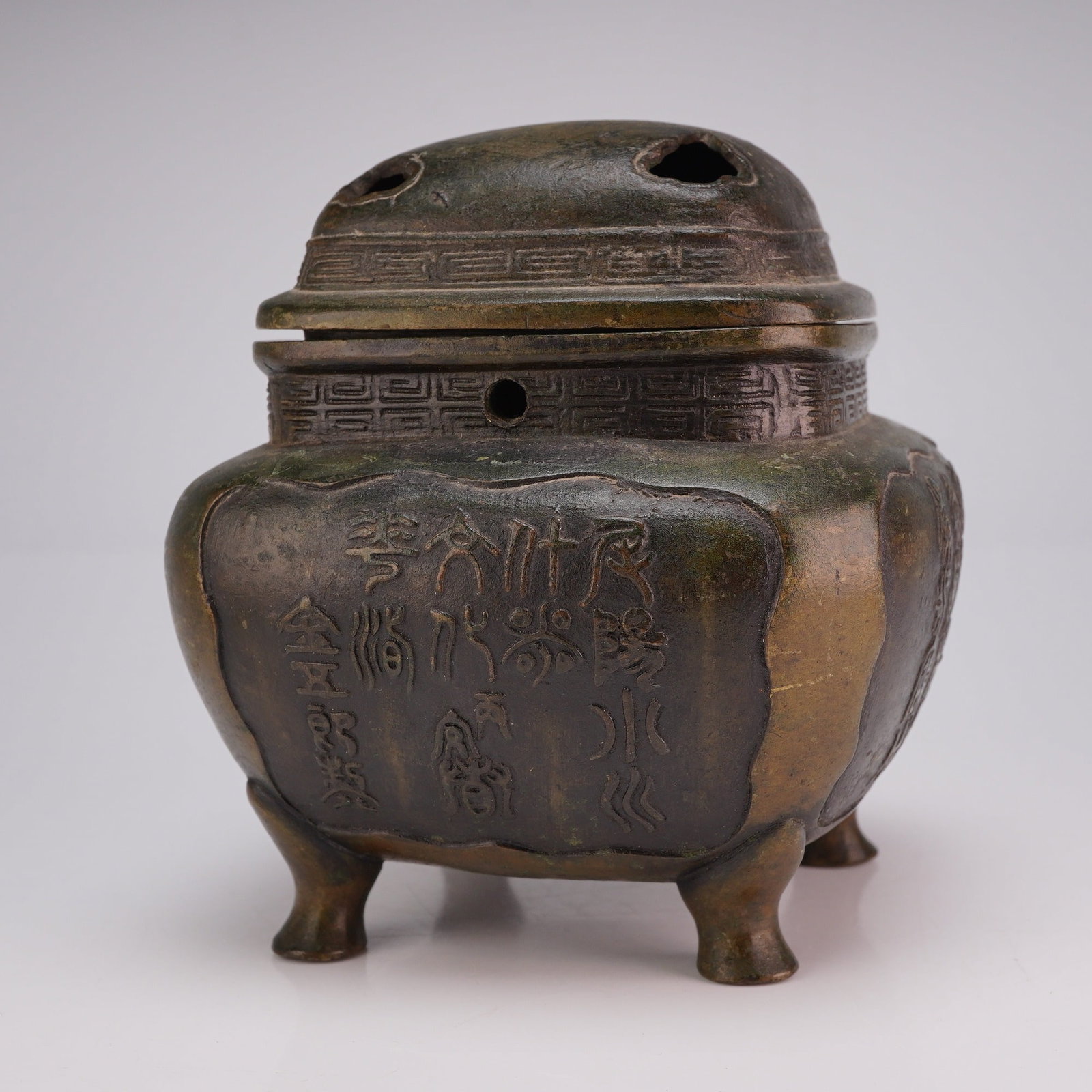Small Bronze Censer, Archaic Script, Pierced Cover: A small footed square-shaped censer with a pierced domed lid, featuring archaic script around the body. Dimensions 4"L x 4"W x 4"H Weight 2.10 lbs