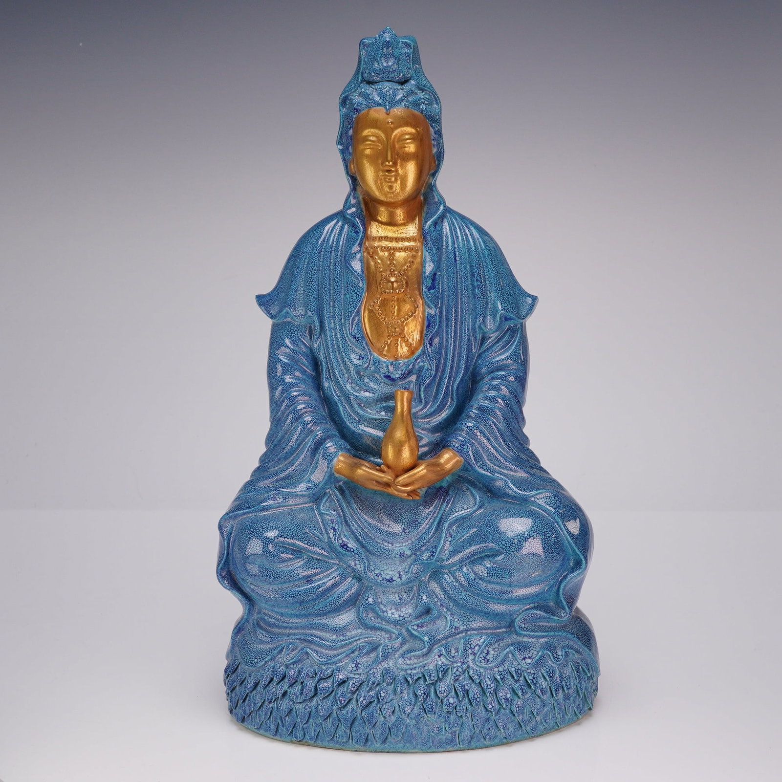 Robins Egg Blue and Gilt Porcelain Seated Guanyin: A porcelain sculpture of a seated Guanyin, finished with a robin's egg blue glaze and gilt accents. Dimensions 6.5"L x 4.5"W x 12.25"H Weight 4.130 lb
