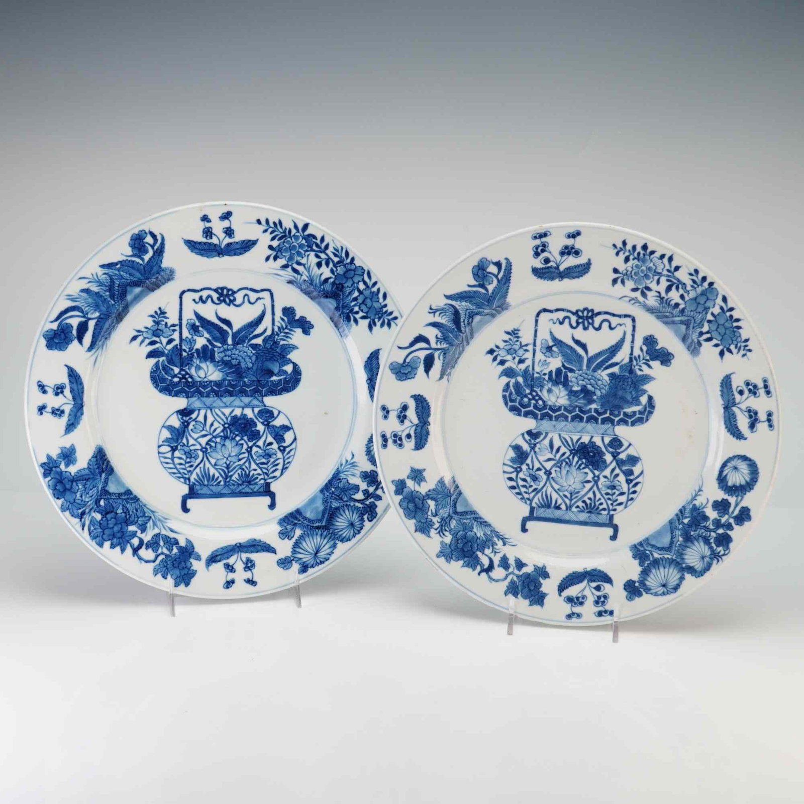 Pair of Chinese Blue and White Porcelain Dishes, Flower Basket, Jue Vessel Mark: A pair of Chinese blue and white porcelain dishes featuring blooming floral and leaf decorations along the rim, with a basket full of flowers at the center, and additional floral motifs on the