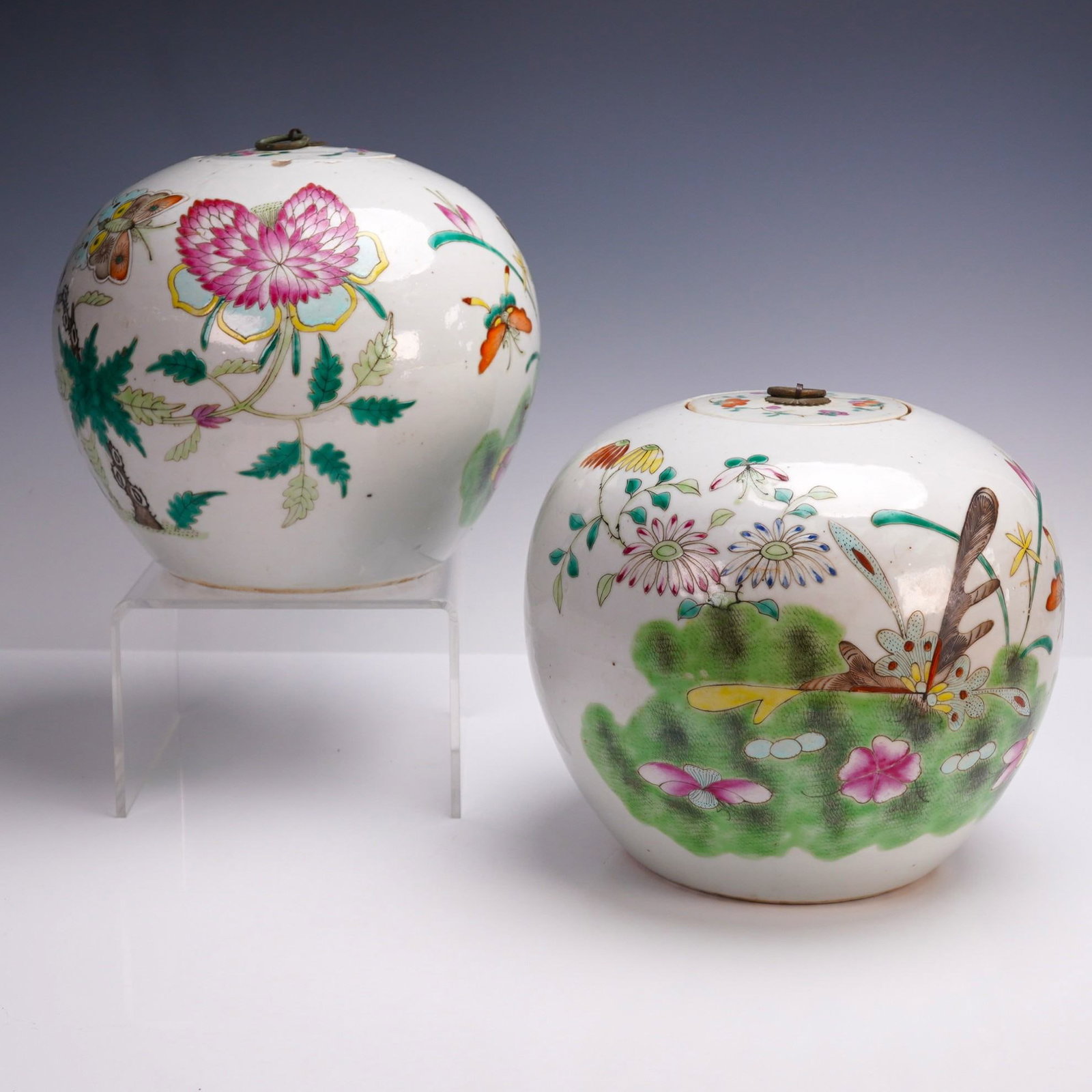 4pc Famille Rose Porcelain Ginger Jars with Lids: A pair of covered ginger jars, each of globular form with domed lids fitted with metal ring handles. The exterior surfaces are decorated in famille rose enamels with floral motifs, foliage, and butter
