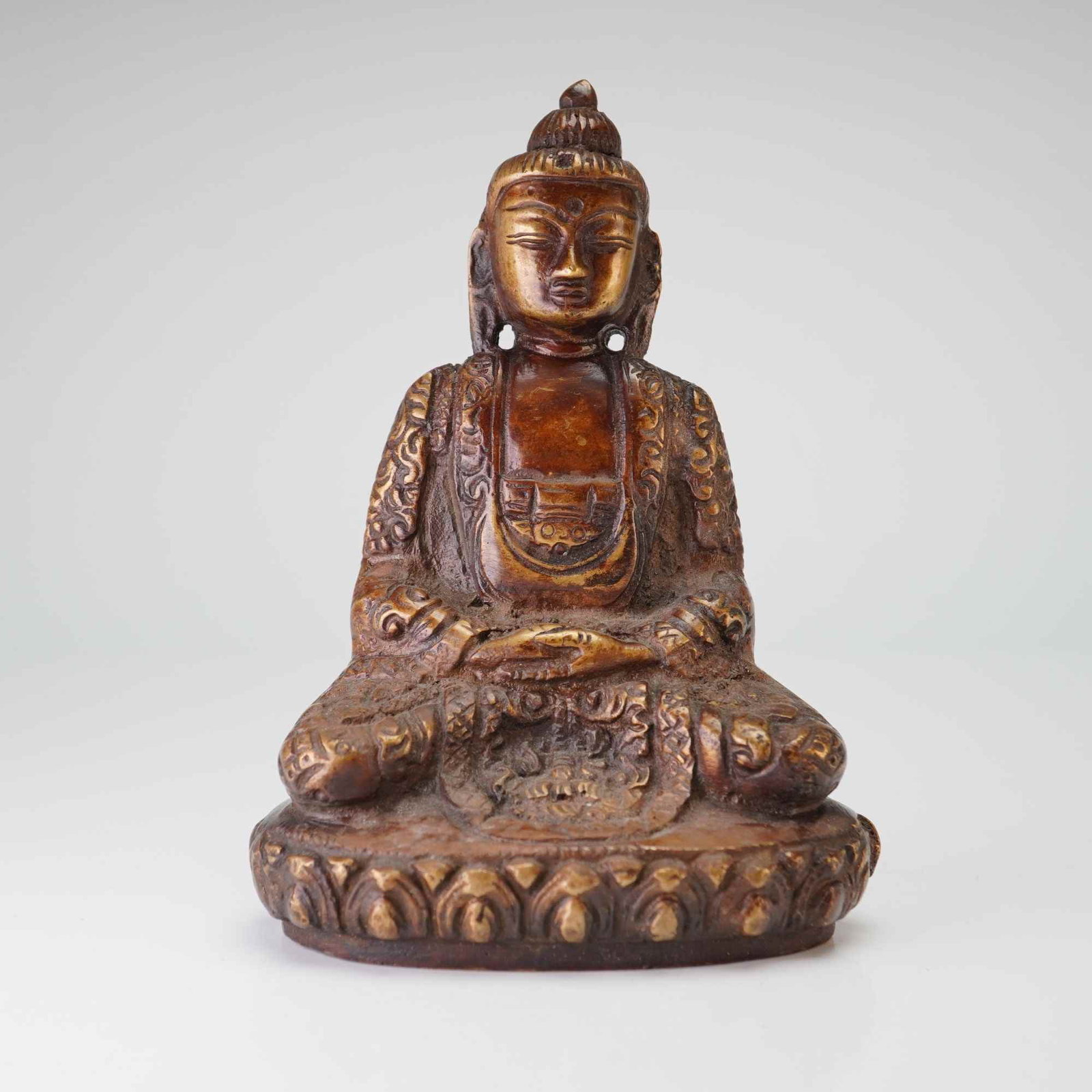 Burmese Cast Bronze Seated Buddha Figurine: A cast bronze Burmese figure of a Buddha seated on a stylized lotus base. Dimensions 3.5"L x 2.75"W x 5"H Weight 1 lb 10 oz