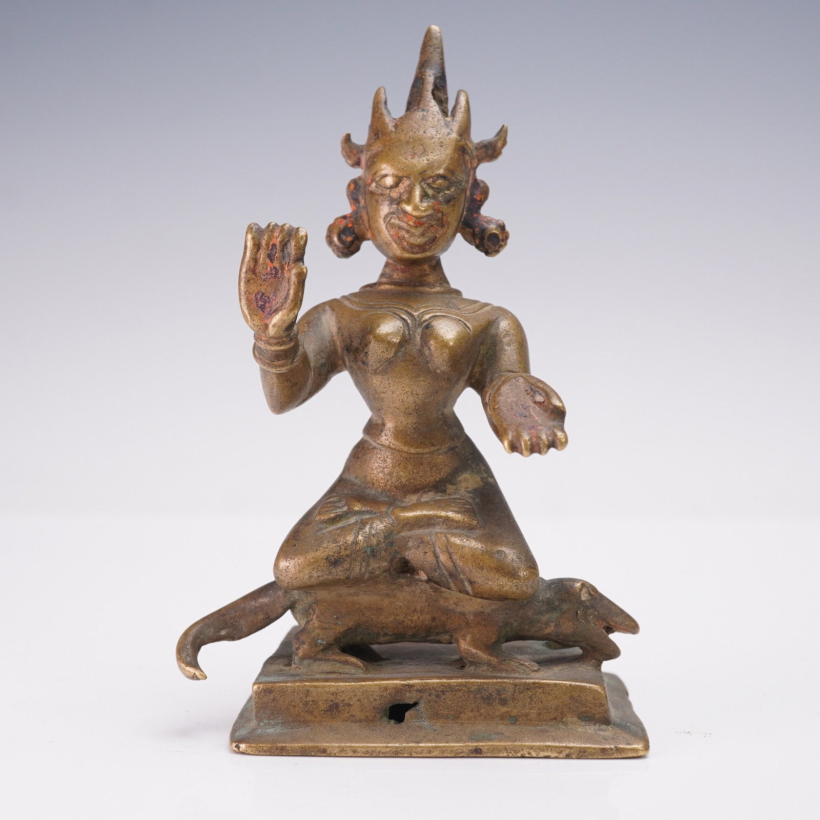Indian Bronze Deity Gauri with Vahana Godha Figurine: Indian bronze figure depicting the Hindu Goddess Gauri, a form of Parvati, shown kneeling on a rectangular plinth. The deity is modeled with an elaborate pointed headdress, ornate hair coils, and styl