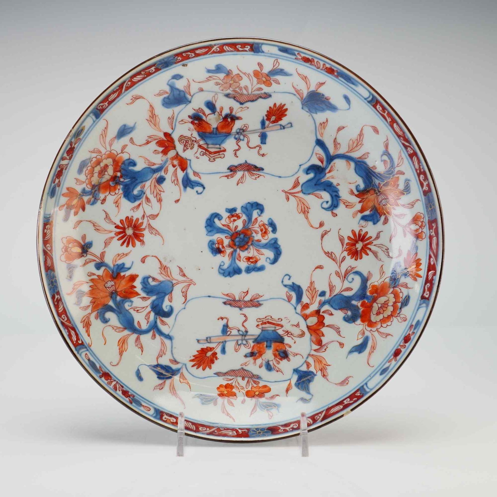 Japanese Imari Small Dish, Flowers and Scholar's Items: A small Japanese Imari dish decorated in hues of red and blue with gilt highlights, featuring flowers and scholar's items. Dimensions 1.5"H x 8.5" dia. Weight 13.0 oz
