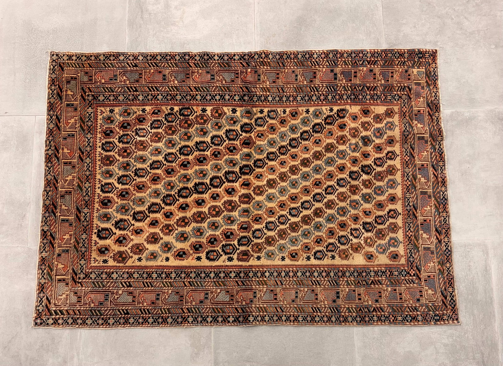 Afghan Turkoman Wool Rug: An Afghan rug executed in the traditional Turkoman (Turkmen) style, distinguished by its classic and highly sought-after repeating octagonal motif. The field displays a structured arrangement of