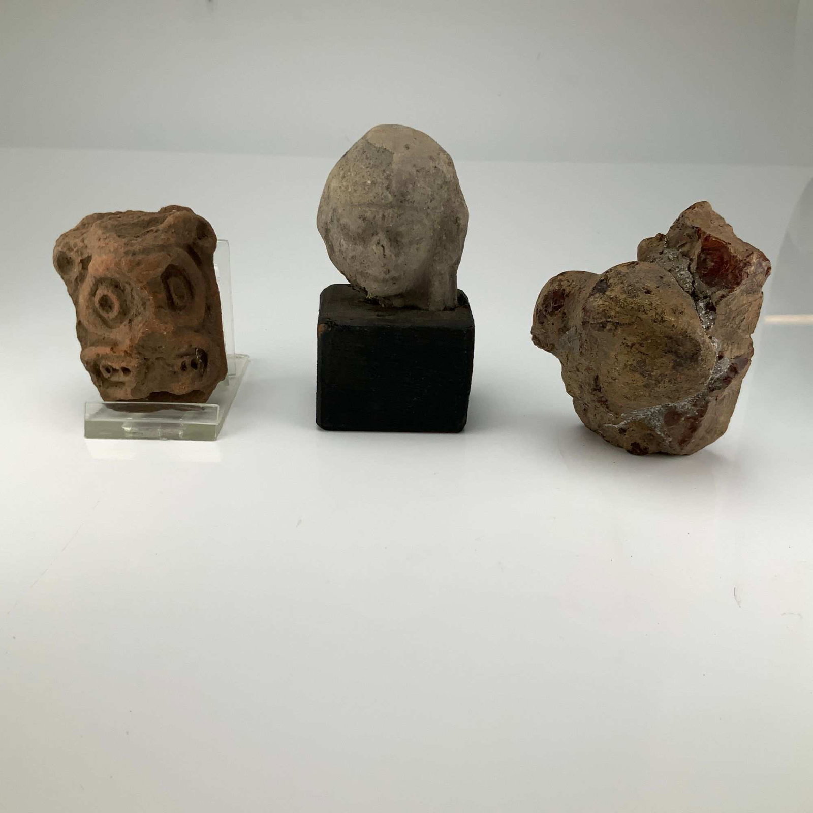 A Trio of Pre-Columbian Style Pottery Shards and a Mineral Specimen: This collection includes archaeological fragments and a natural mineral specimen. The group features a terracotta pottery shard decorated with incised concentric circles and spiral motifs, which is mo