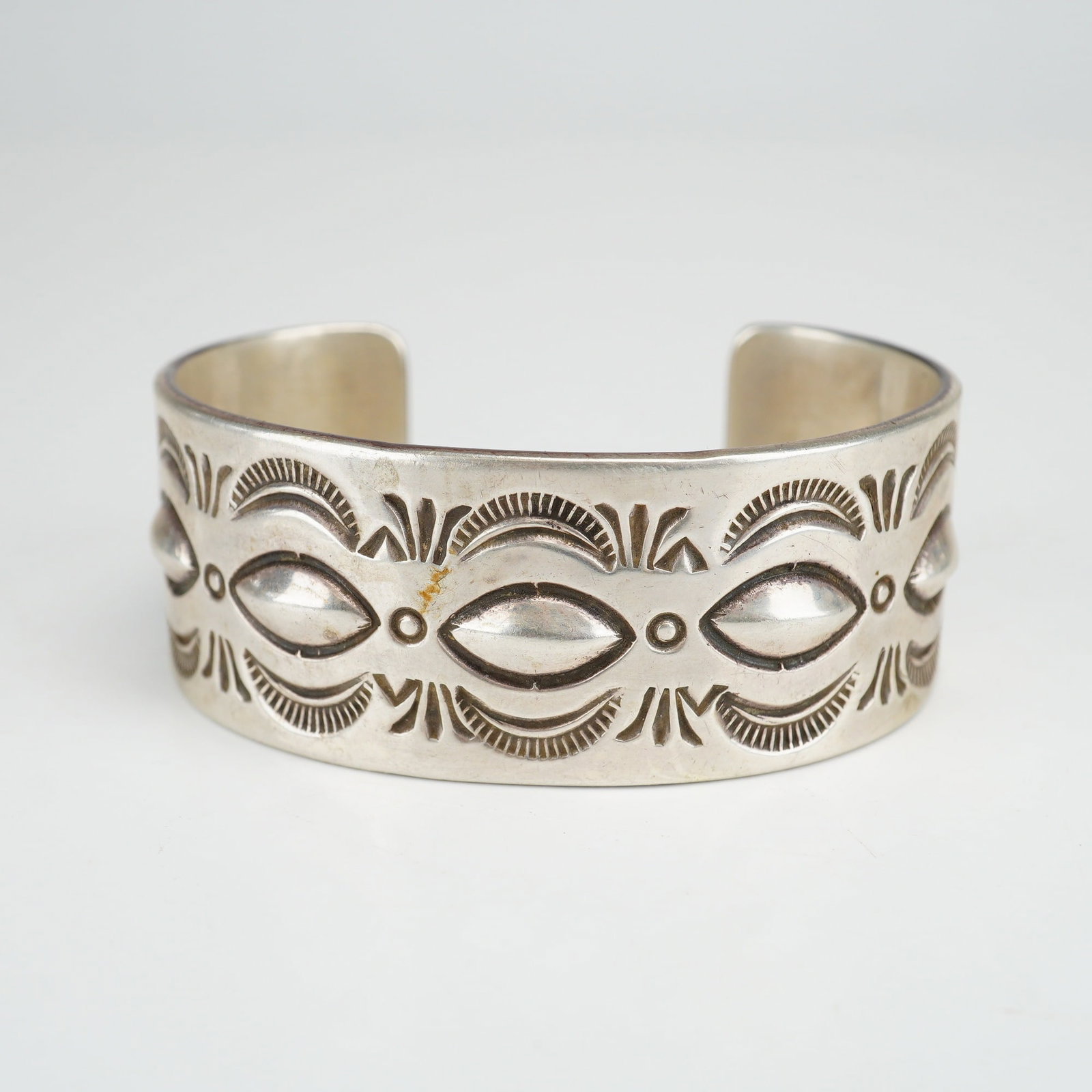 Native American Navajo J. Billie Sterling Silver Cuff Bracelet: This Native American Indian cuff is handcrafted in sterling silver by Navajo silversmith J. Billie. The wide cuff design features a central row of raised, almond-shaped repousse bosses. The exterior s