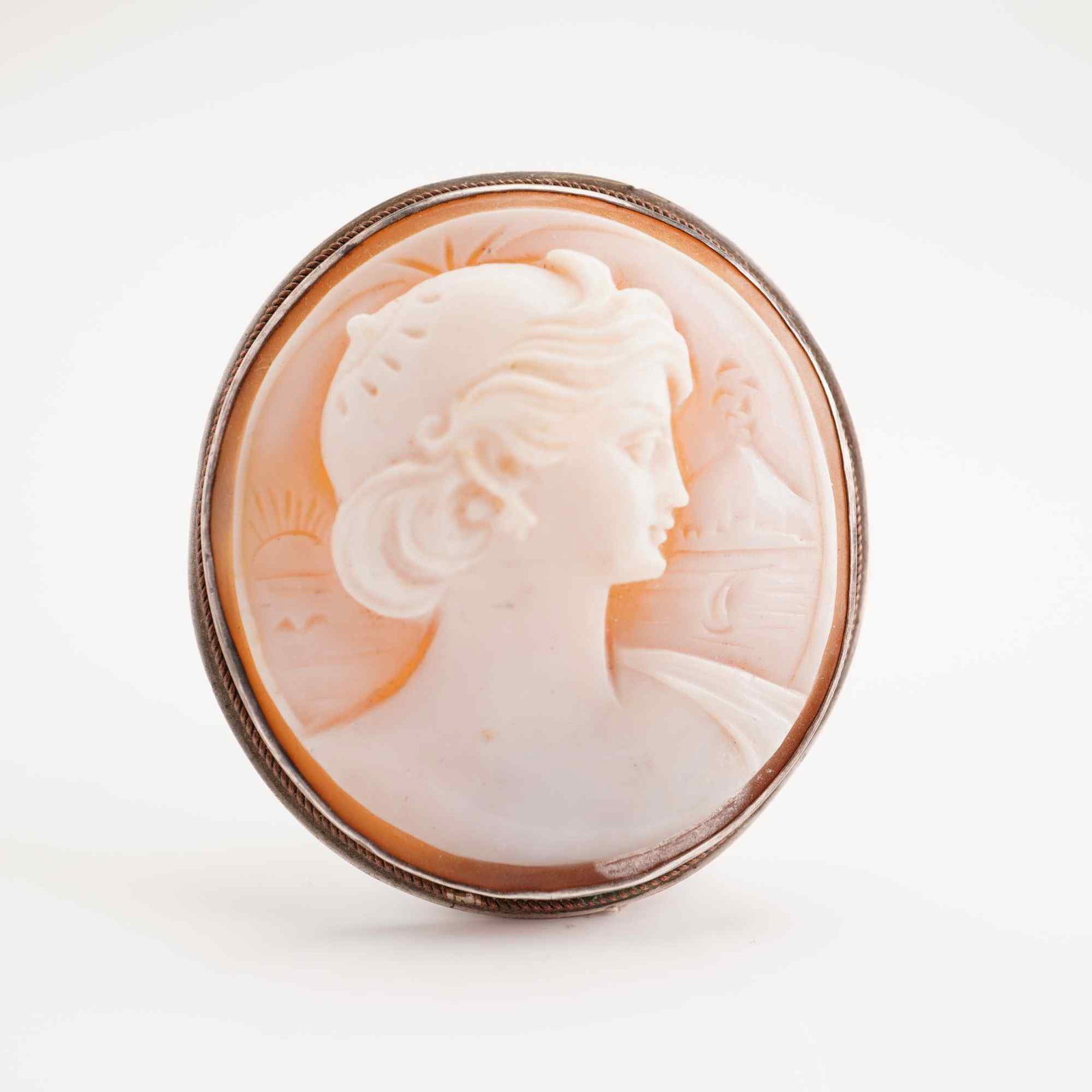 900 Silver Hand Carved Shell Cameo Brooch Pendant: An oval shell cameo featuring a hand-carved classical profile of a woman facing right. The carving is executed on a carnelian shell, displaying a white relief layer against a warm peach-orange ground.