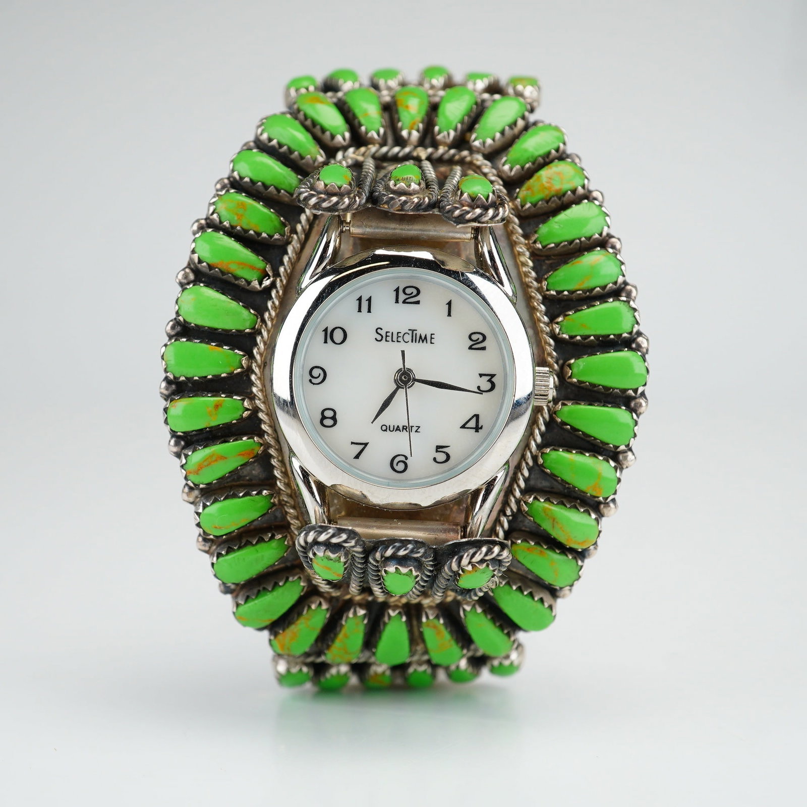 Navajo Sterling Silver and Gaspeite Cluster Watch Cuff Bracelet: A Native American Navajo sterling silver watch cuff bracelet featuring a cluster design. The bracelet is constructed with a multi-wire frame supporting an extensive arrangement of teardrop-shaped