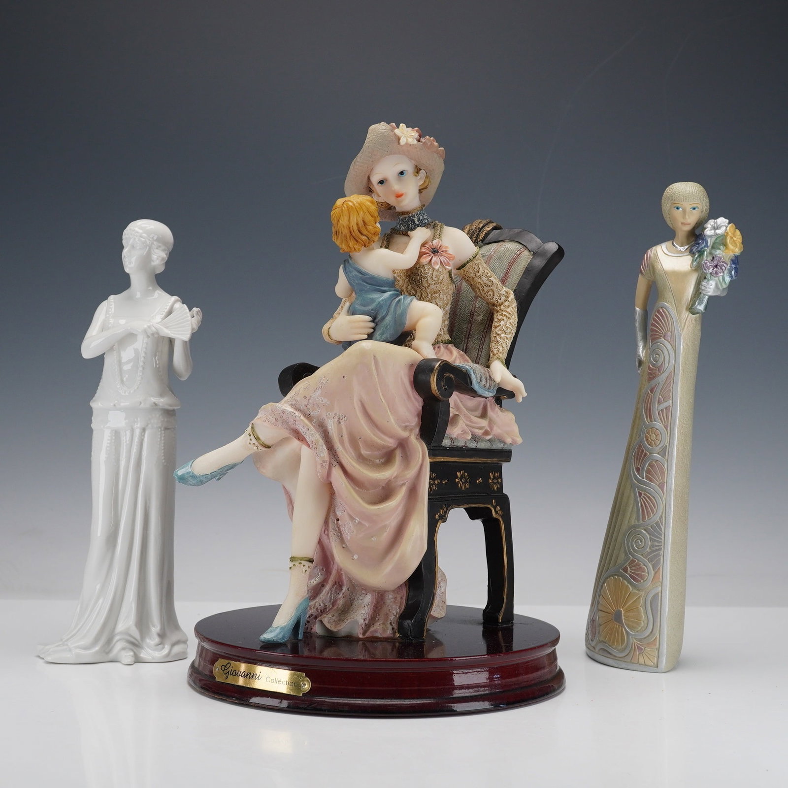 3pc Turtle King & Parastone Vintage Lady Figurines: This charming trio includes a Giovanni Collection piece by Turtle King, featuring a finely detailed lady in a hat seated on an ornate chair with a young child in her arms, mounted on a wooden base wit