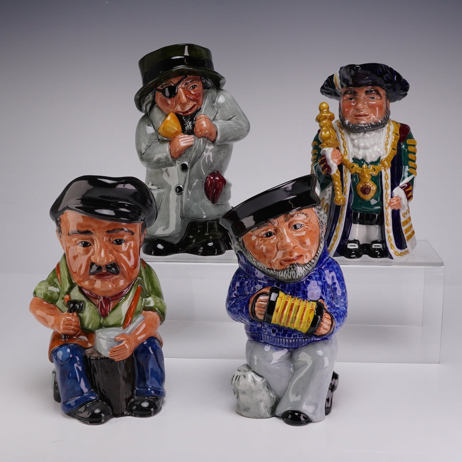 4pc English Ceramic Toby Jugs by Staffordshire Fine Ceramics: This collection consists of four glazed earthenware Toby jugs by Staffordshire Fine Ceramics. Each jug is modeled as a full-bodied figure with an integral handle formed by the back of the character. T