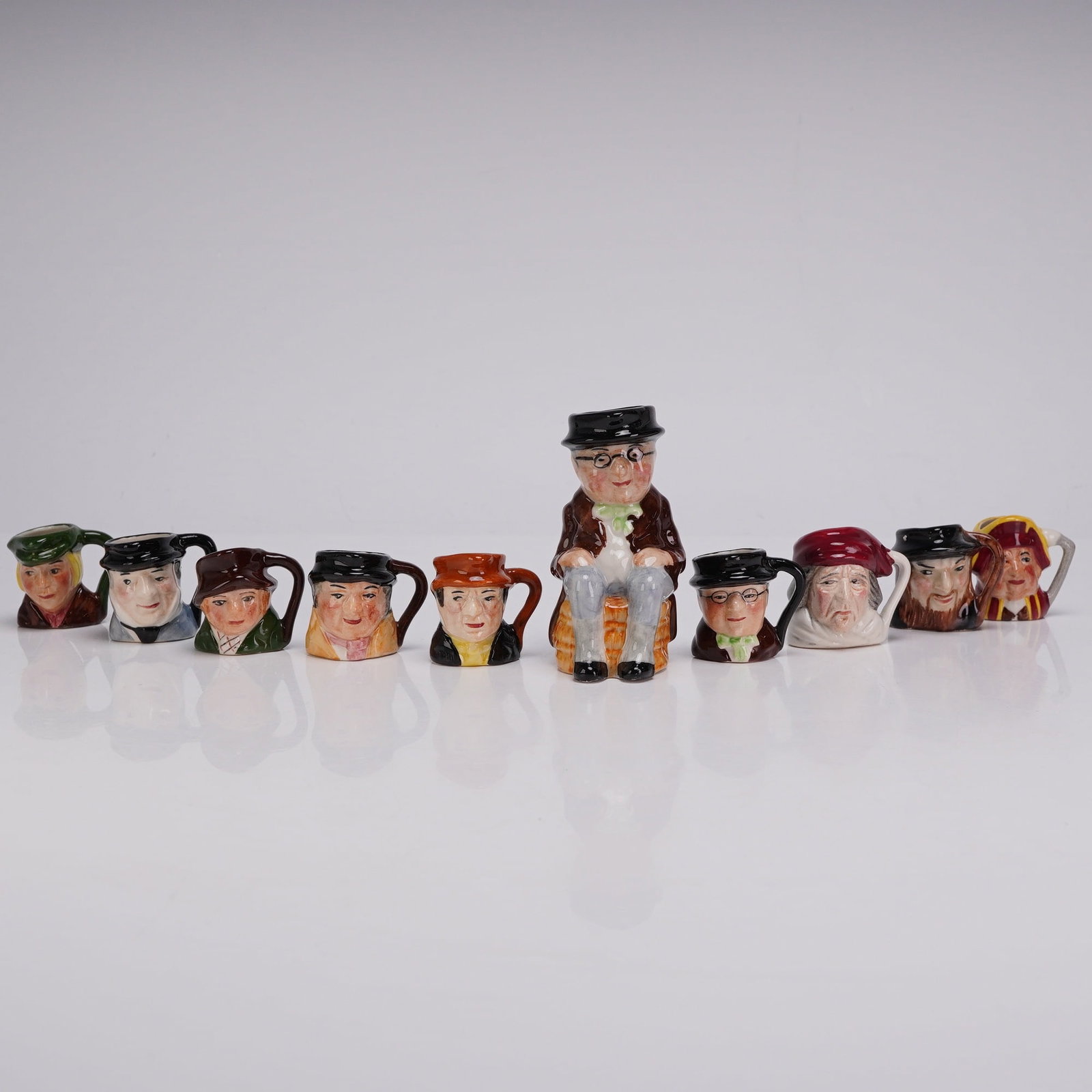 10pc Artone England Miniature Dickens Character Jugs and One Toby: This collection of glazed earthenware pottery features characters from the novels of Charles Dickens, manufactured by Artone in England. The set consists of nine miniature character jugs and one toby 