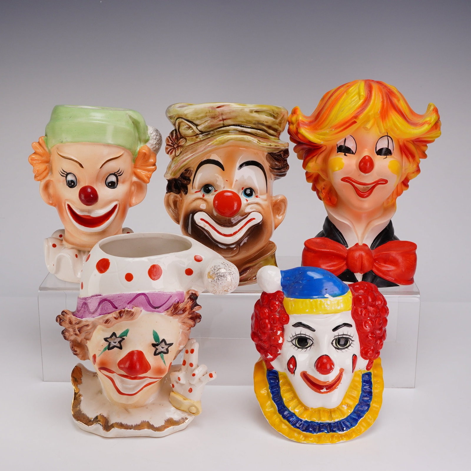 5pc Ceramic Clown Head Vases including Napco, Inarco & Lefton: This collection of five clown heads consists of mid-20th-century ceramic figural planters manufactured in Japan for the American giftware market. The assortment includes identified examples from Napco