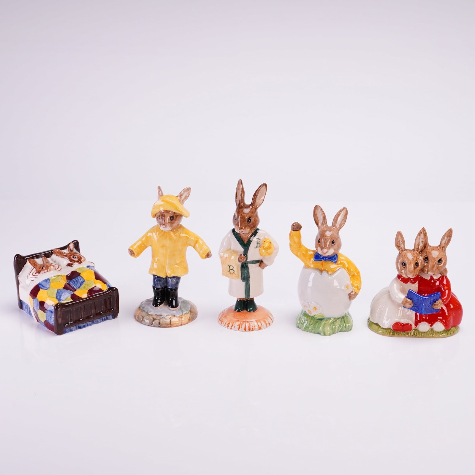 Collection of Five Royal Doulton Bunnykins Glazed Figurines: A collection of five late 20th-century anthropomorphic rabbit figurines from the Royal Doulton Bunnykins series, crafted from glazed ceramic, likely porcelain, with detailed hand-painted decoration. T