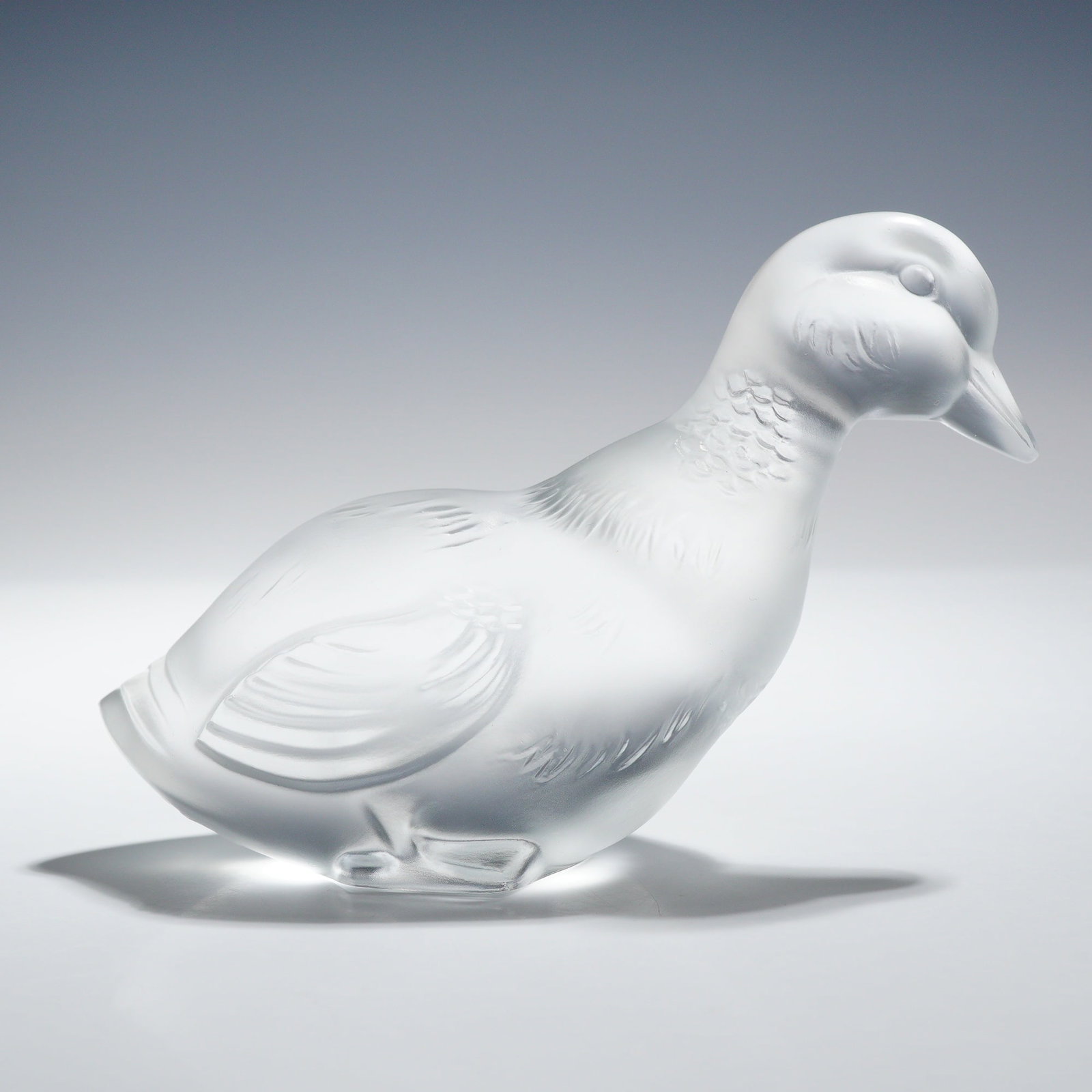 Baccarat Frosted Crystal Figurine, Duck: The piece features molded and textured feather detailing across the neck, wings, and tail. The underside bears the circular acid-etched Baccarat mark. Dimensions: 5.50"L x 3.50"W x 2.00"H Weight: 15.0