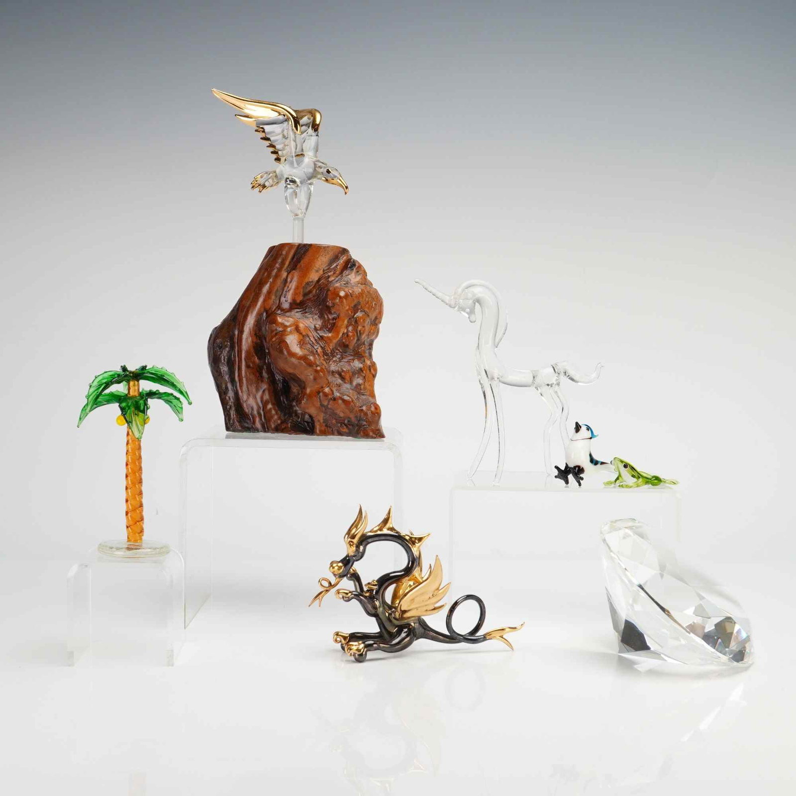 Glass Baron and Artisan, 7pc Glass Menagerie Figurines and Large Chaton: This seven-piece collection features an assortment of hand-blown and faceted glass figurines. The set includes a clear glass eagle with 22 karat gold accents, attributed to Glass Baron, mounted via a 