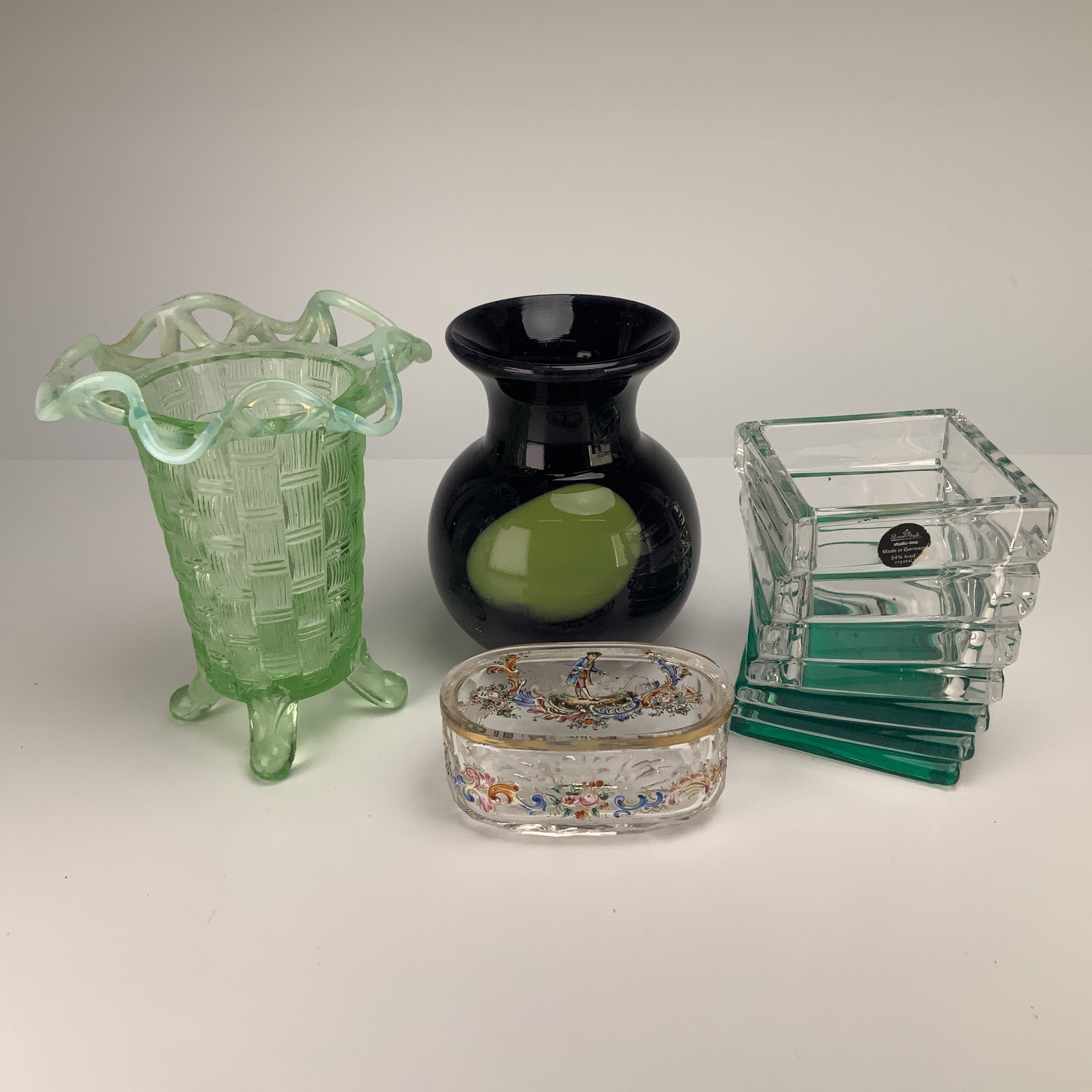 4pc Art Glass Vessels and Lidded Box, including Rosenthal Studio & Uranium Glass Vase: This lot features four pieces of art glass including a Rosenthal Studio-Line Turnus 24 percent lead crystal stacked glass vessel. This modern architectural piece is designed with horizontally ribbed s