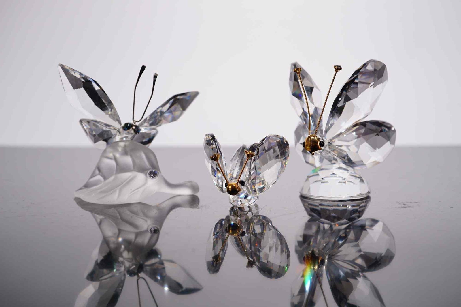Swarovski Silver Crystal, Three Butterfly Figurines including Butterfly on Leaf: A collection of three Swarovski Silver Crystal figurines from the Insects and Butterflies series. The set includes a Butterfly on Leaf, model number 182920, featuring a clear faceted crystal butterfly