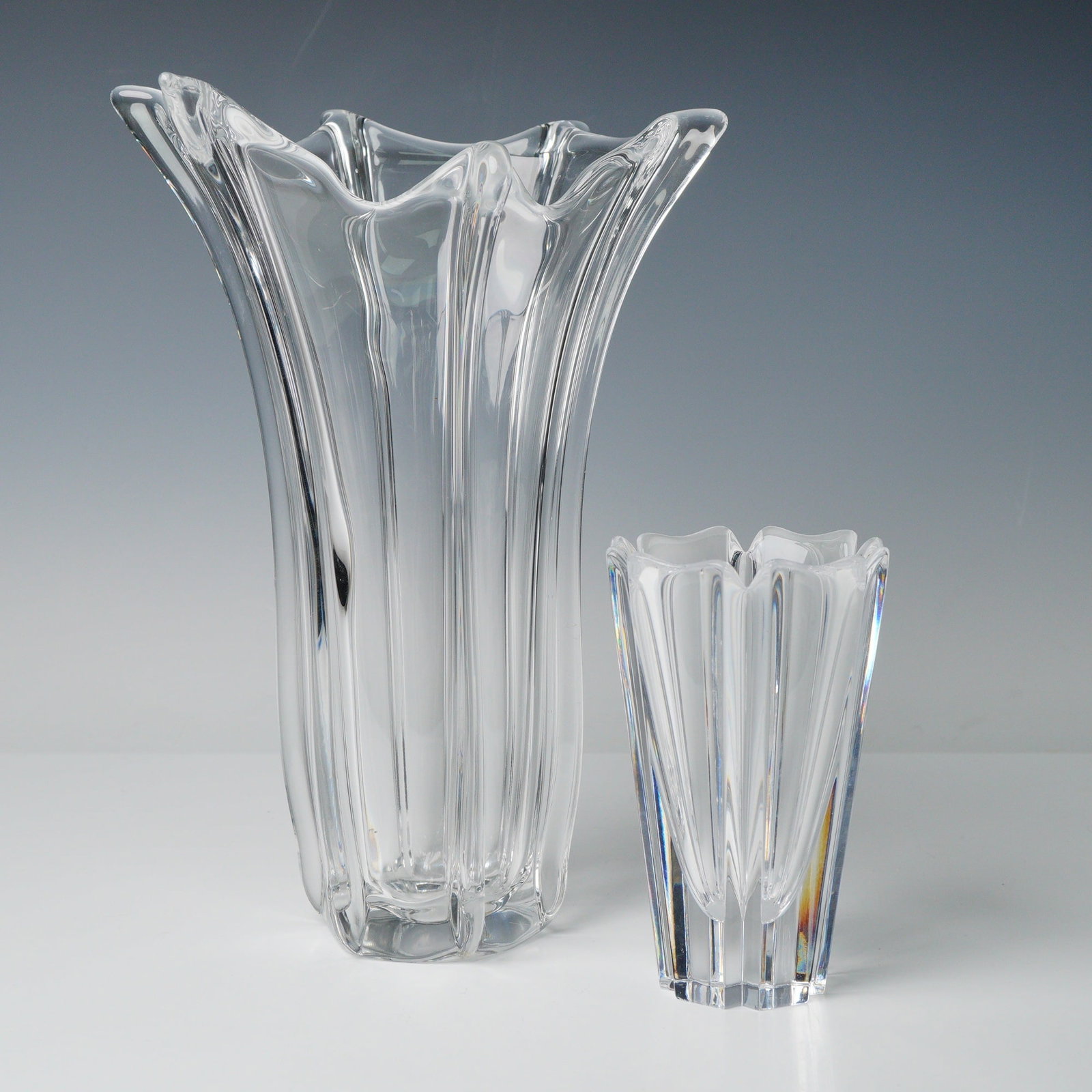 A Pair of Orrefors Clear Crystal 'Sutter' Vases: A pair of clear crystal art glass vessels, attributed to Orrefors, Sweden, featuring a heavy modernist design commonly known in the market as the 'Sutter' pattern. The lot includes two items: one tall