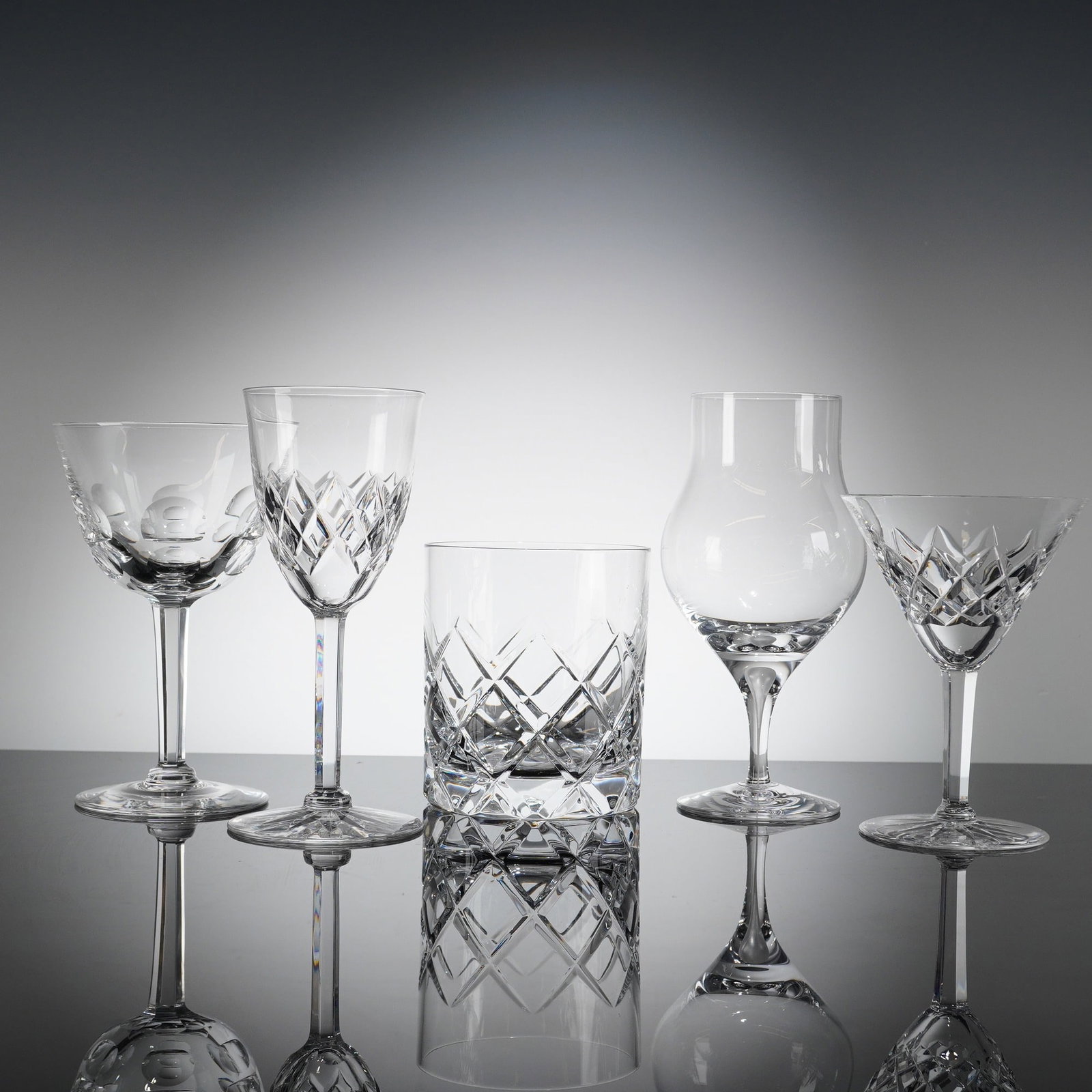 A Collection of Five Orrefors Elisabeth Crystal Glasses: A collection of five Orrefors Crystal glasses, atributed to the 'Elisabeth' patern, though comprising various forms. The set includes two stemmed goblets/wine glasses, one short rocks tumbler, one ste