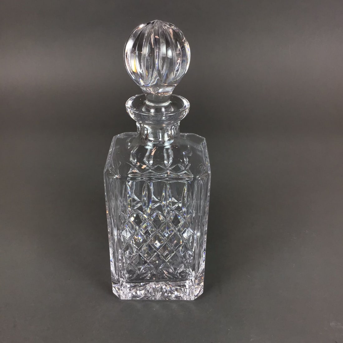 Waterford Crystal Square Spirit Decanter with Stopper, Lismore: The piece is identified as Waterford crystal by the acid-etched mark in Gothic script on the base. It is decorated in the Lismore pattern, which consists of a band of diamond crisscross cuts topped by
