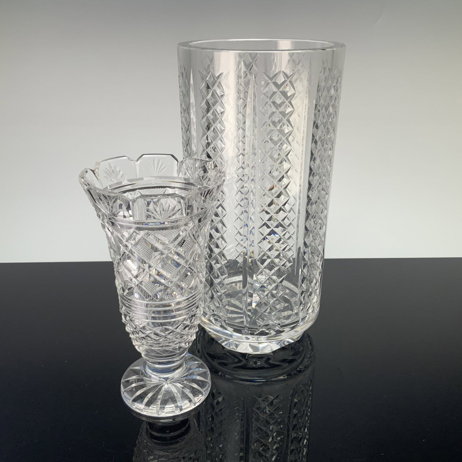 2pc Waterford Crystal Vases, Georgian Strawberry & Hibernia Patterns: Two pieces of Waterford lead crystal. The first item, in the Hibernia pattern, is a large cylindrical vase featuring vertical columns of diamond-cut panels separated by deep mitre cuts, finished with 