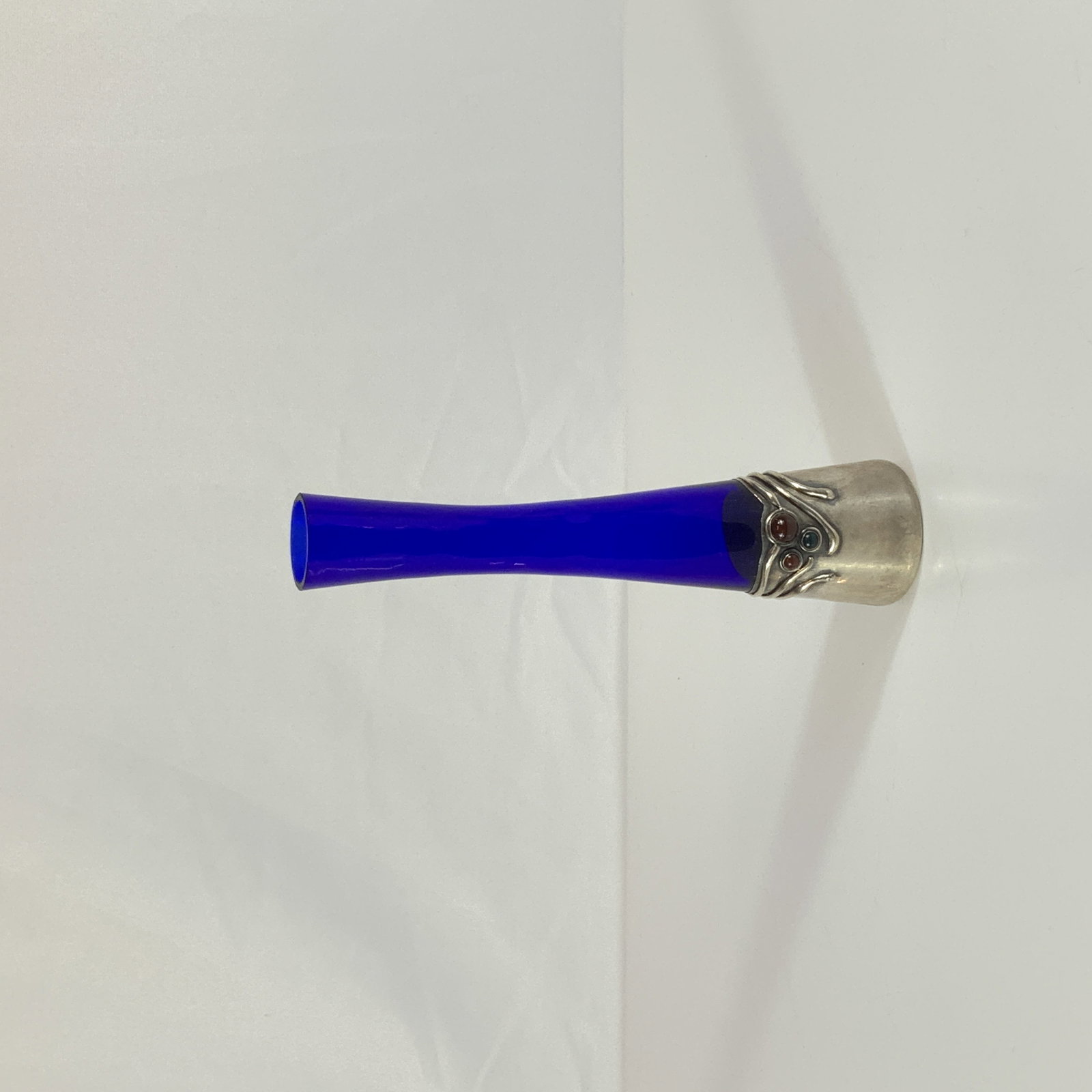Donar Israel Sterling Silver and Cobalt Blue Glass Bud Vase with Inset Stones: This bud vase features a slender tapered body of cobalt blue glass. The vessel is mounted into a sterling silver base designed with organic wirework and three inset cabochon cut stones in shades of re