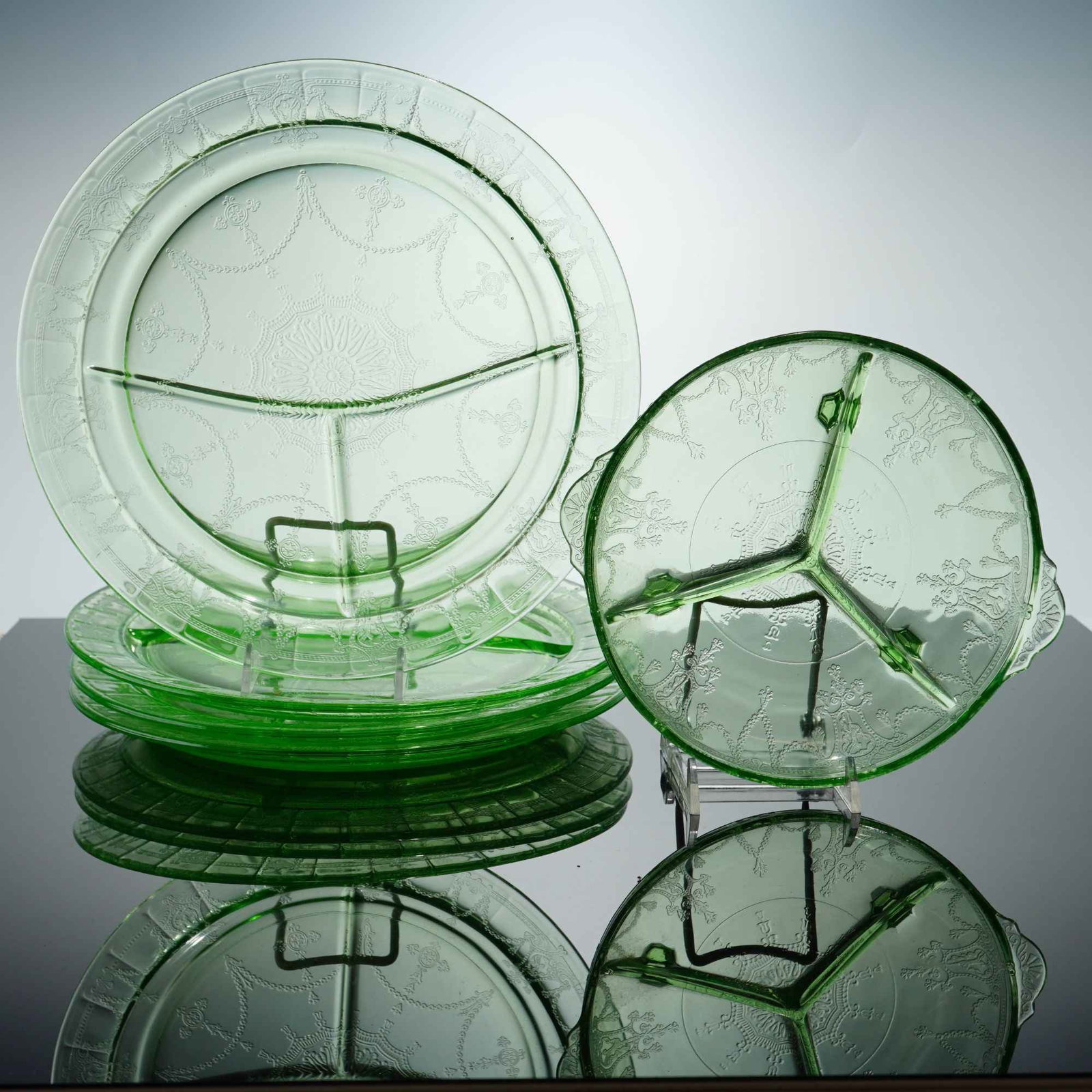 Set of Five Anchor Hocking Cameo Pattern Green Depression Glass Divided Plates and Relish Dish: Five pieces is composed of green depression glass in the Cameo pattern, also known as Ballerina, produced by Anchor Hocking. The collection includes five circular grill plates and one handled relish d
