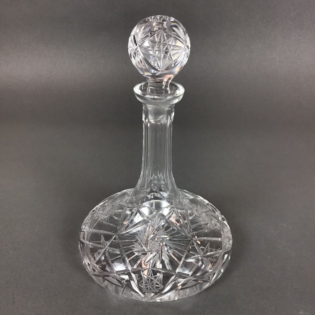 Crystal Ships Decanter with Stopper in the American Brilliant Style: This item is a hand-cut lead crystal ship's decanter with a matching spherical stopper. The form is characterized by a wide, low-profile disc base, historically referred to as a captain's or ship's de