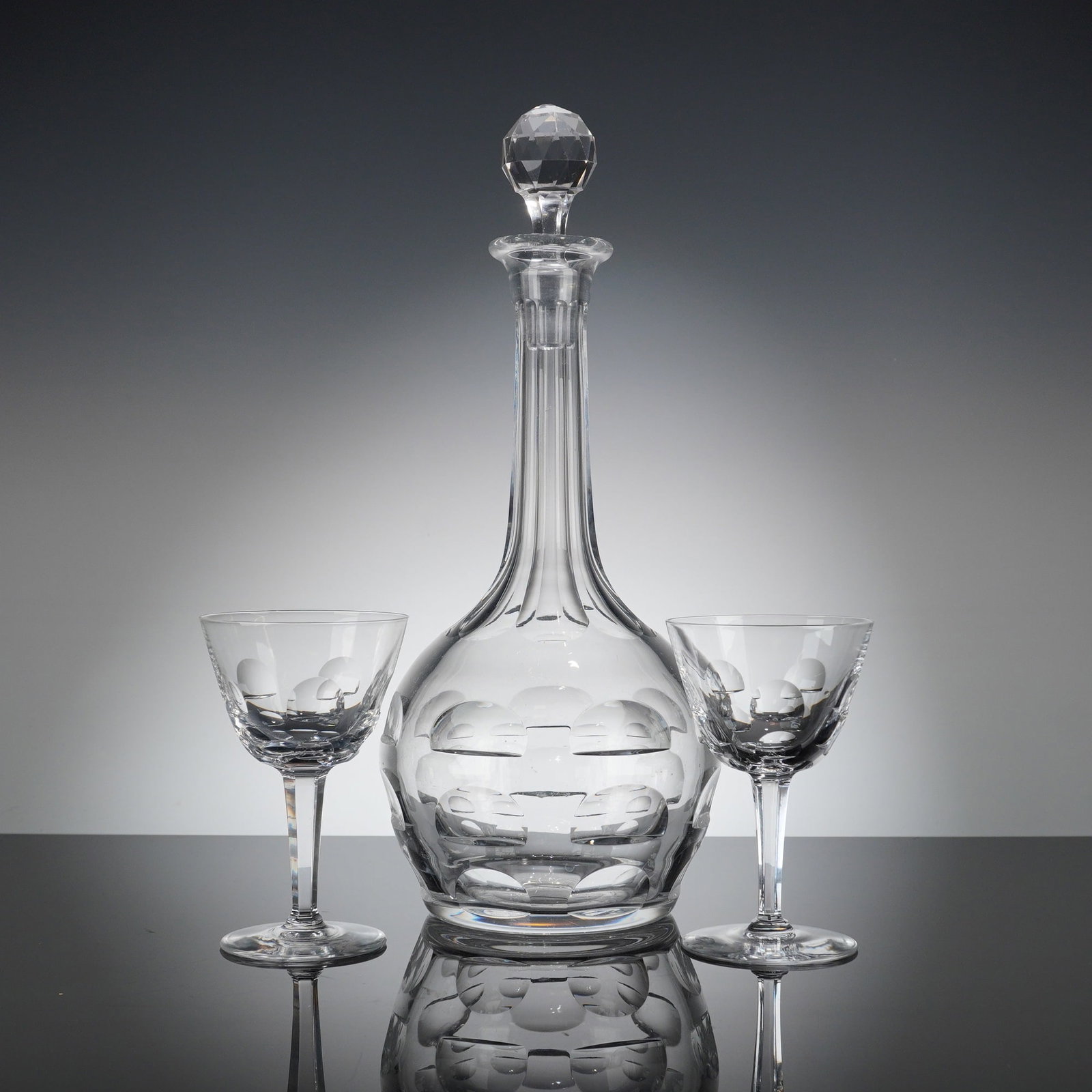 3pc Cut Crystal Decanter and Wine Glasses Set: A set consisting of one cut crystal decanter with its original stopper and a pair of matching stemmed wine glasses. The glassware is made from clear, heavy lead crystal or high-quality glass. The deca