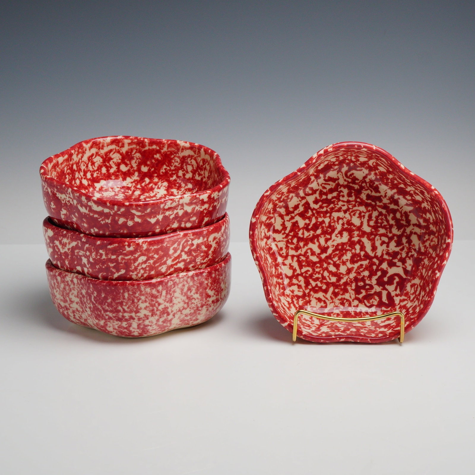 4pc Henn Pottery Red Spongeware Petal Bowls: This set of 4 earthenware bowls is designed in a five-lobed petal form with a scalloped, undulating rim. Each bowl is decorated using a spongeware technique with a mottled red glaze over a