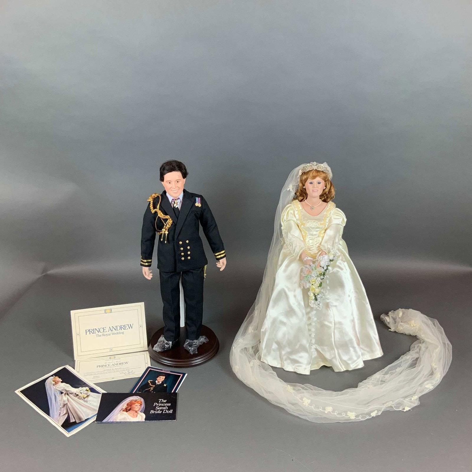 Two The Danbury Mint Bisque Dolls The Royal Wedding Prince Andrew and The Princess Sarah Bride: Produced by The Danbury Mint, these two dolls commemorate the July 23, 1986, royal wedding of Prince Andrew and Sarah Ferguson. Each doll features a head, lower arms, and lower legs crafted from fine 
