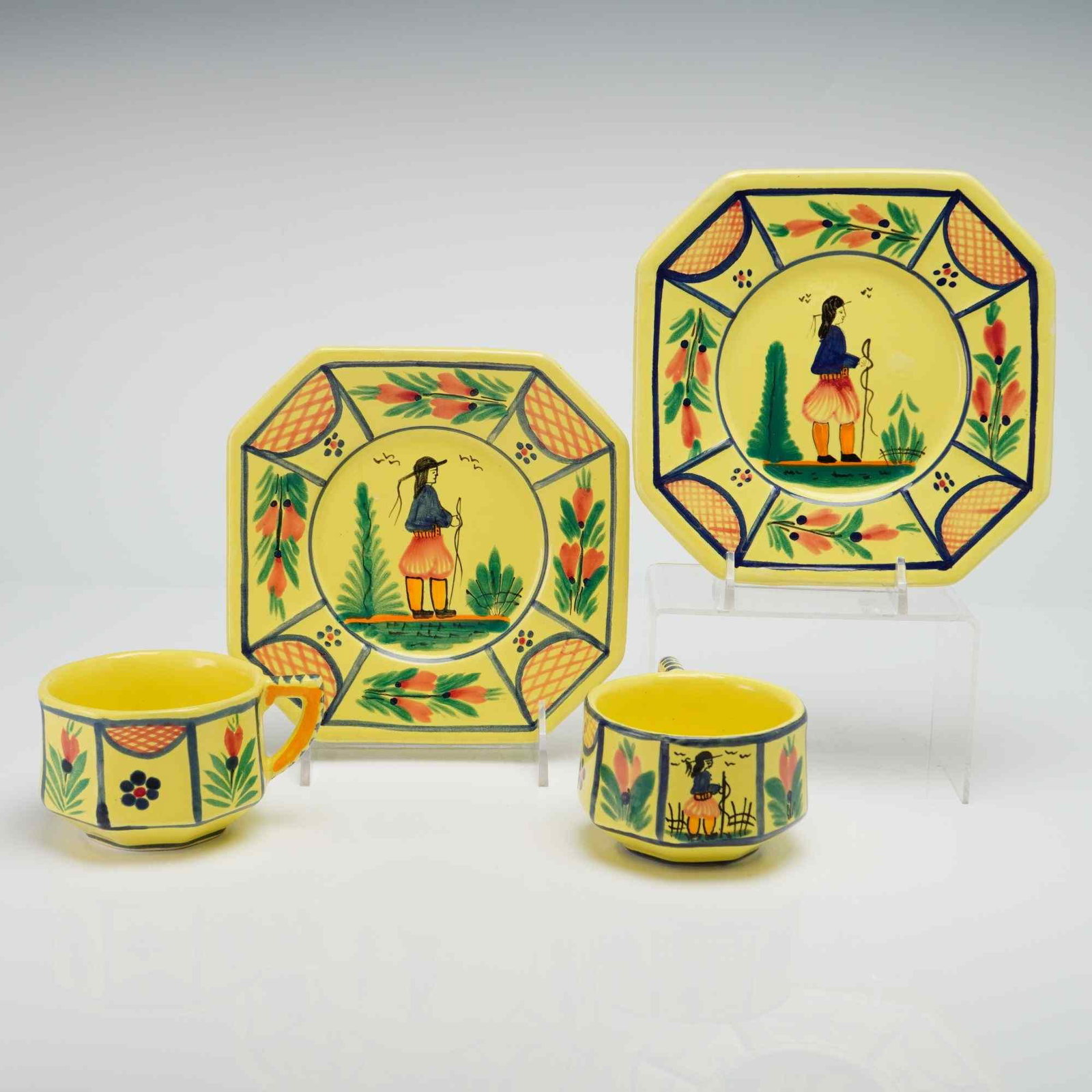 Set of Four HB Quimper Soleil Yellow Faience Cups and Plates: This set of French faience glazed earthenware is produced by the HB Quimper factory in the Soleil Yellow pattern. The collection features faceted, eight-sided cups and octagonal plates decorated in th