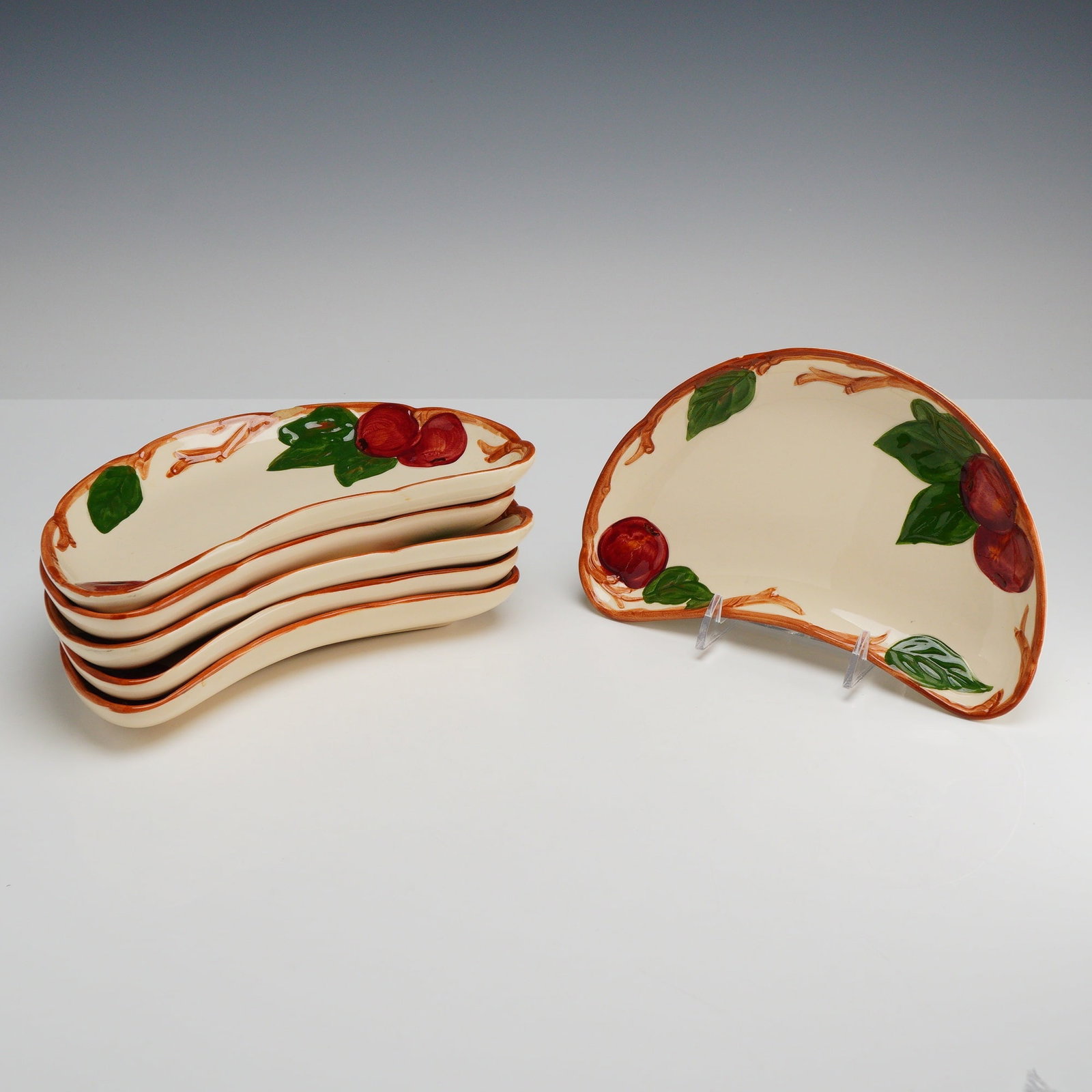 Set of Six Franciscan Earthenware Crescent Plates, Apple Pattern: This set of 6 apple tree ceramic plates features the Apple pattern by Franciscan. The pieces are made of cream-colored earthenware with relief-molded decoration. The hand-painted design depicts red ap