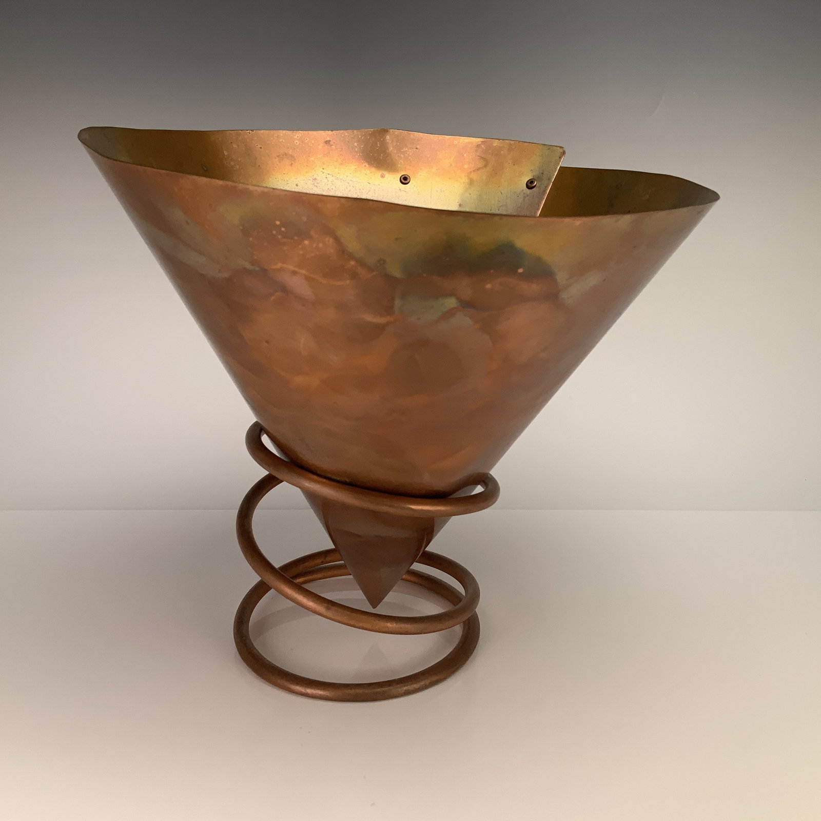 Contemporary Studio Art Copper Funnel Signed and Dated 1996: This contemporary studio art copper funnel is constructed from a sheet of copper rolled into a conical form. The seam is secured with two visible rivets near the rim. The exterior surface features a p