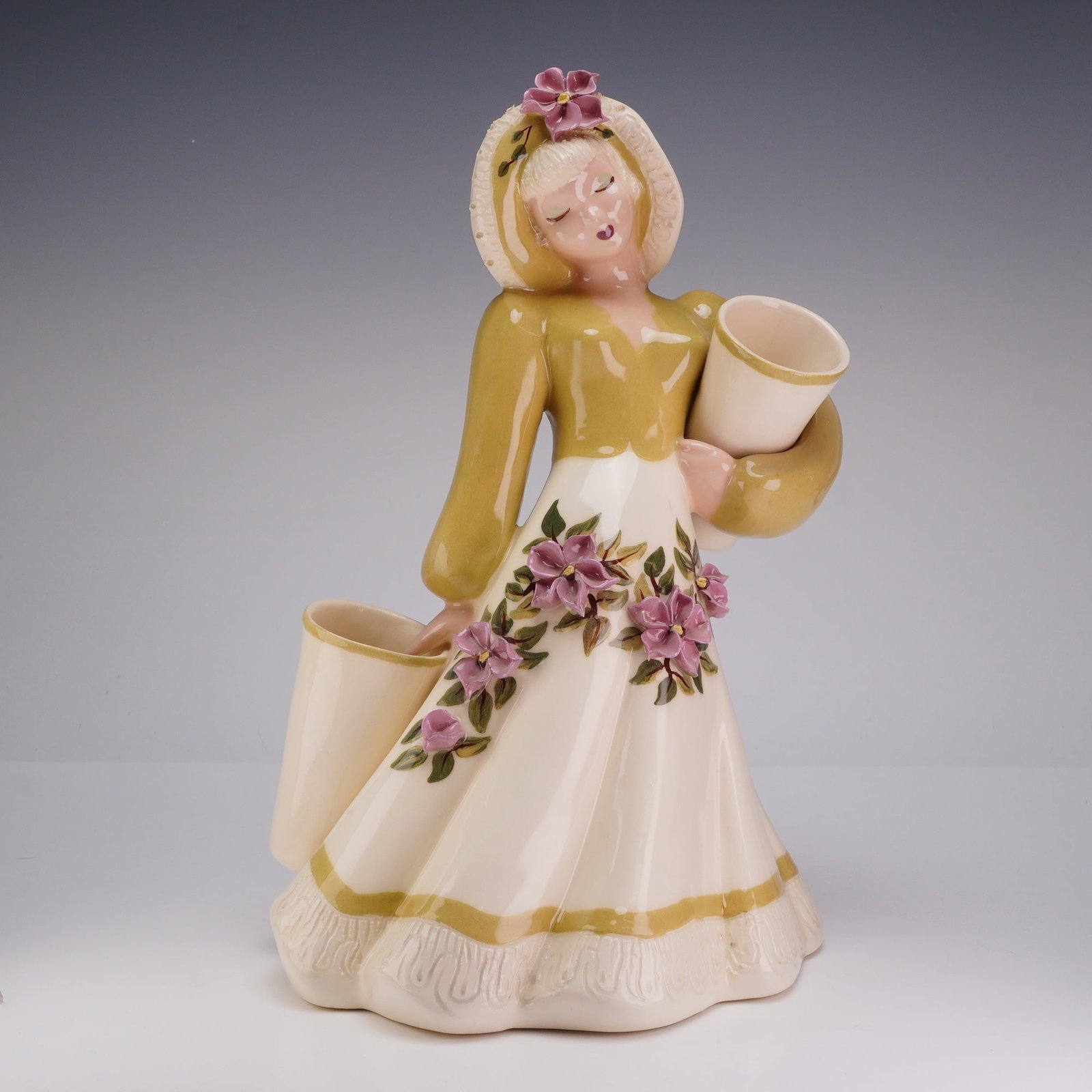 Hedi Schoop California Pottery Figural Double Planter Vase: This mid-century glazed ceramic figurine was produced by Hedi Schoop in Hollywood, California. The piece depicts a woman in stylized period dress, featuring a wide-brimmed bonnet with an applied pink 