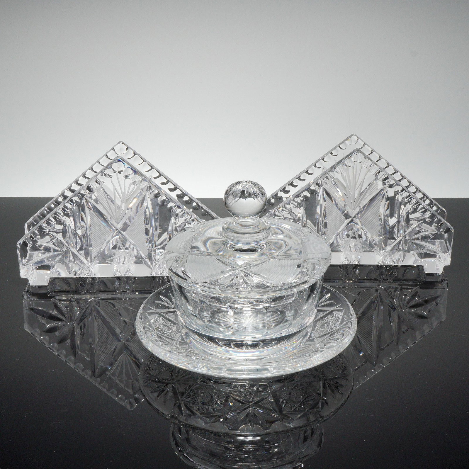 3pc Czech Republic Crystal Napkin Holders and Jewelry Box: A collection of three pieces of clear, hand cut lead crystal. The group consists of two matching triangular napkin holders and one covered jewelry box with a fitted lid topped by a spherical finial. T
