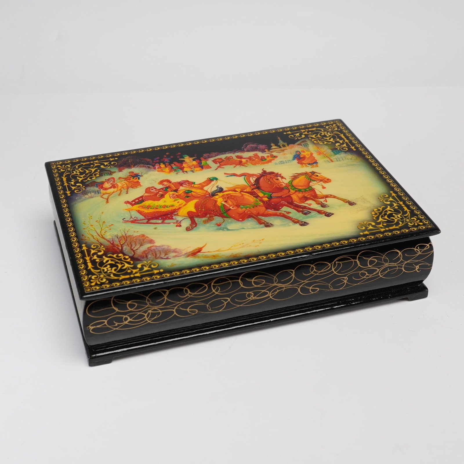 Russian Lacquer Papier-Mache Box with Hand-Painted Troika Scene: This rectangular Russian box is constructed from papier-mache with a high-gloss black lacquer exterior and a characteristic red lacquer interior. The lid features a hand-painted miniature illustration