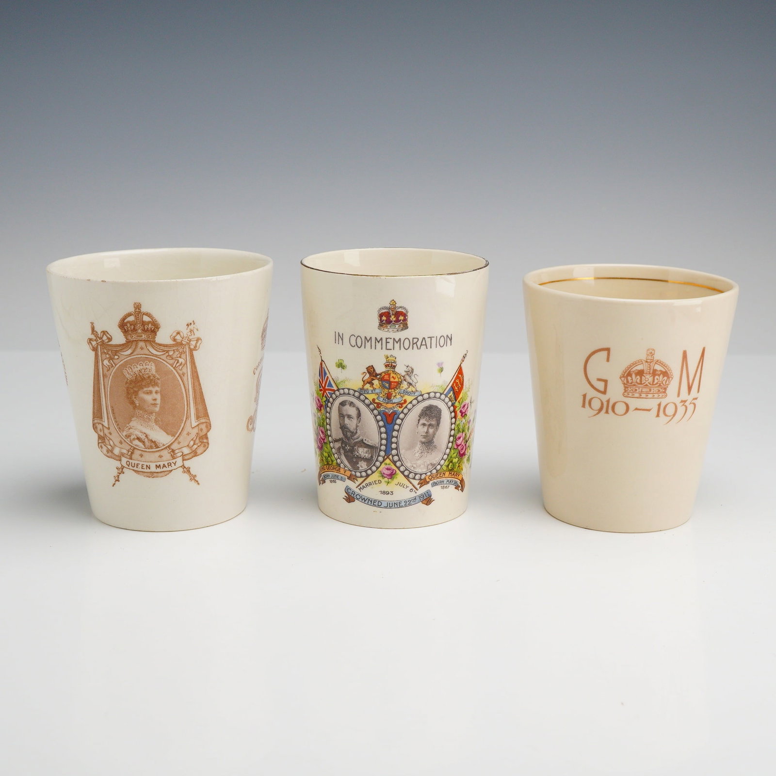 3pc King George V and Queen Mary Commemorative Ceramic Tumblers: This lot features a trio of ceramic commemorative beakers celebrating the reigns of King George V and Queen Mary. The first item is a 1911 Coronation beaker by Royal Doulton, constructed of fine earth